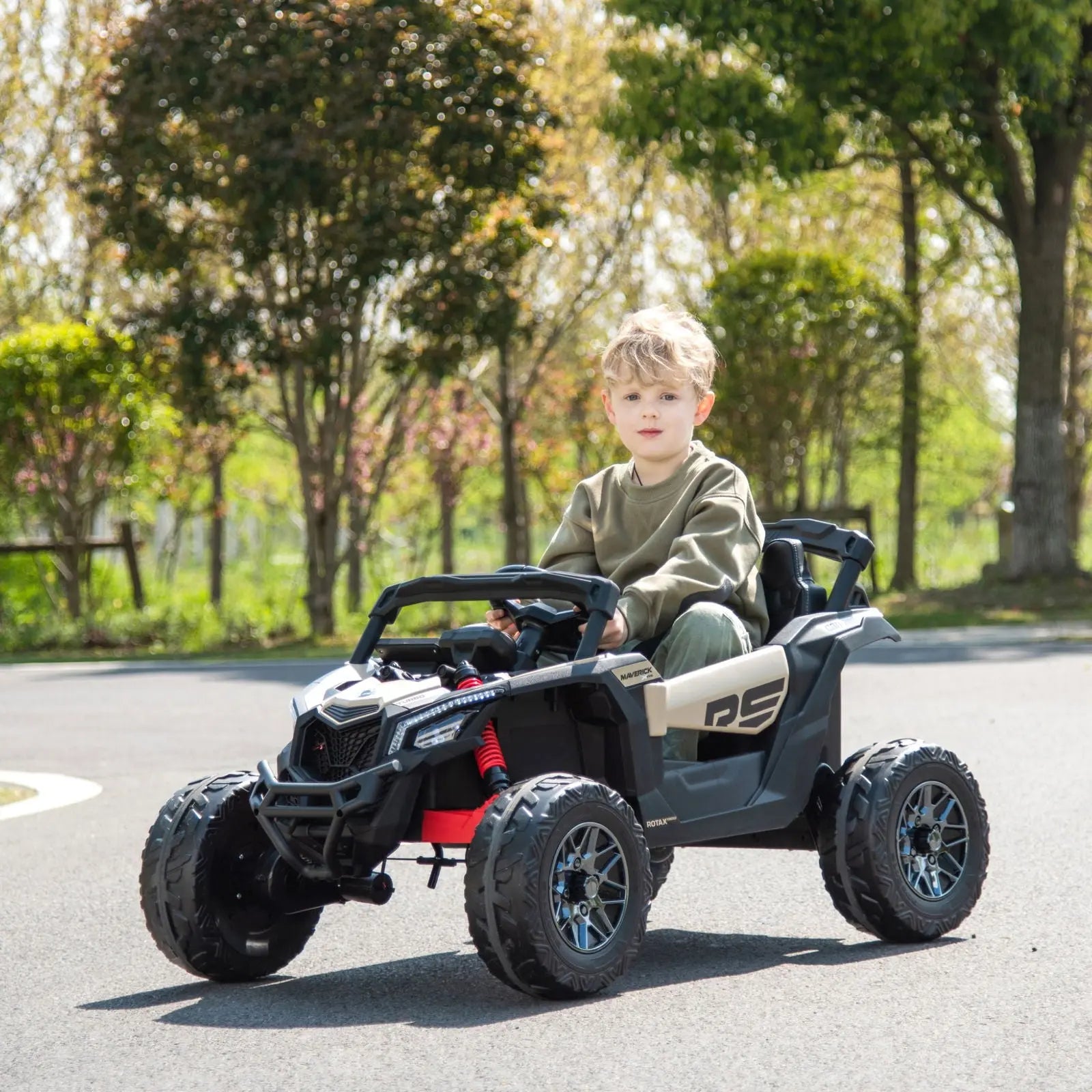 Child riding a 24V black and beige Can-Am Maverick kids electric ride-on UTV outdoors