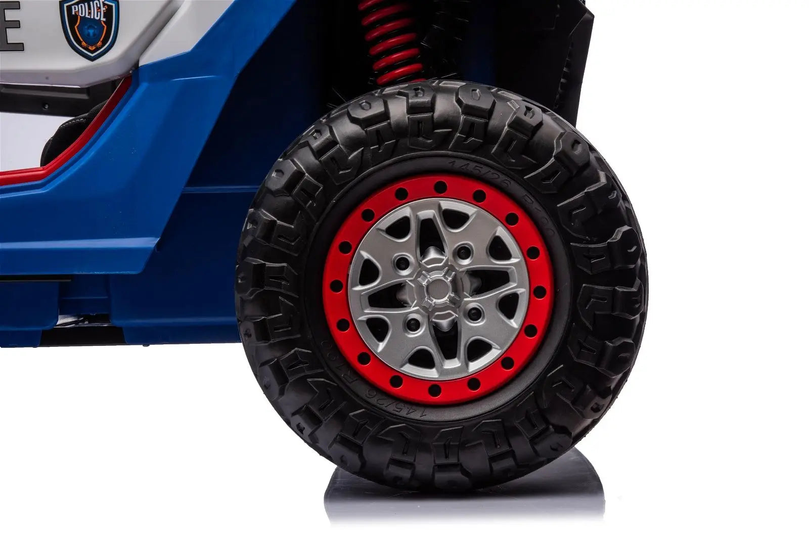 Close-up of rugged black and red toy UTV tire with police badge decal