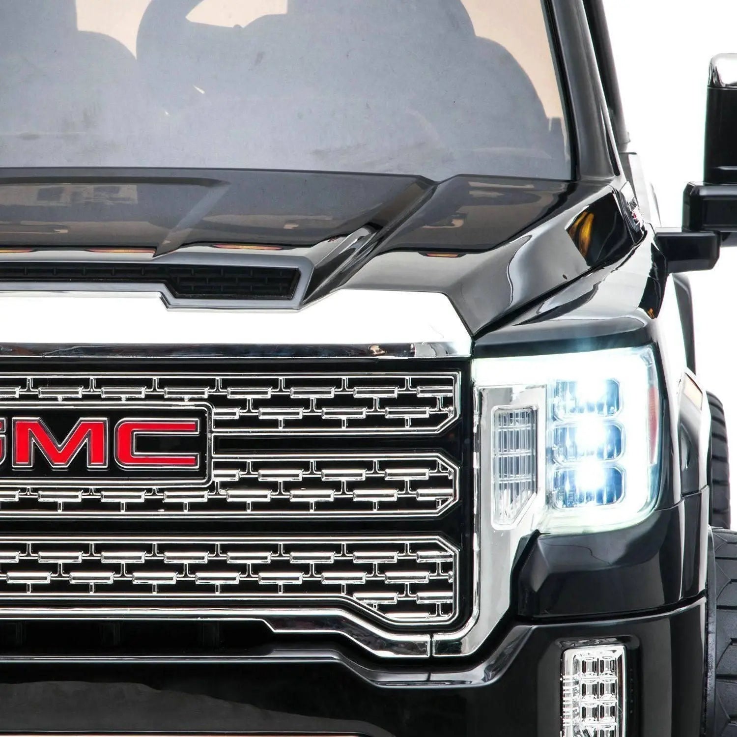 Close-up of black 24V two-seater GMC Denali ride-on car with LED headlights