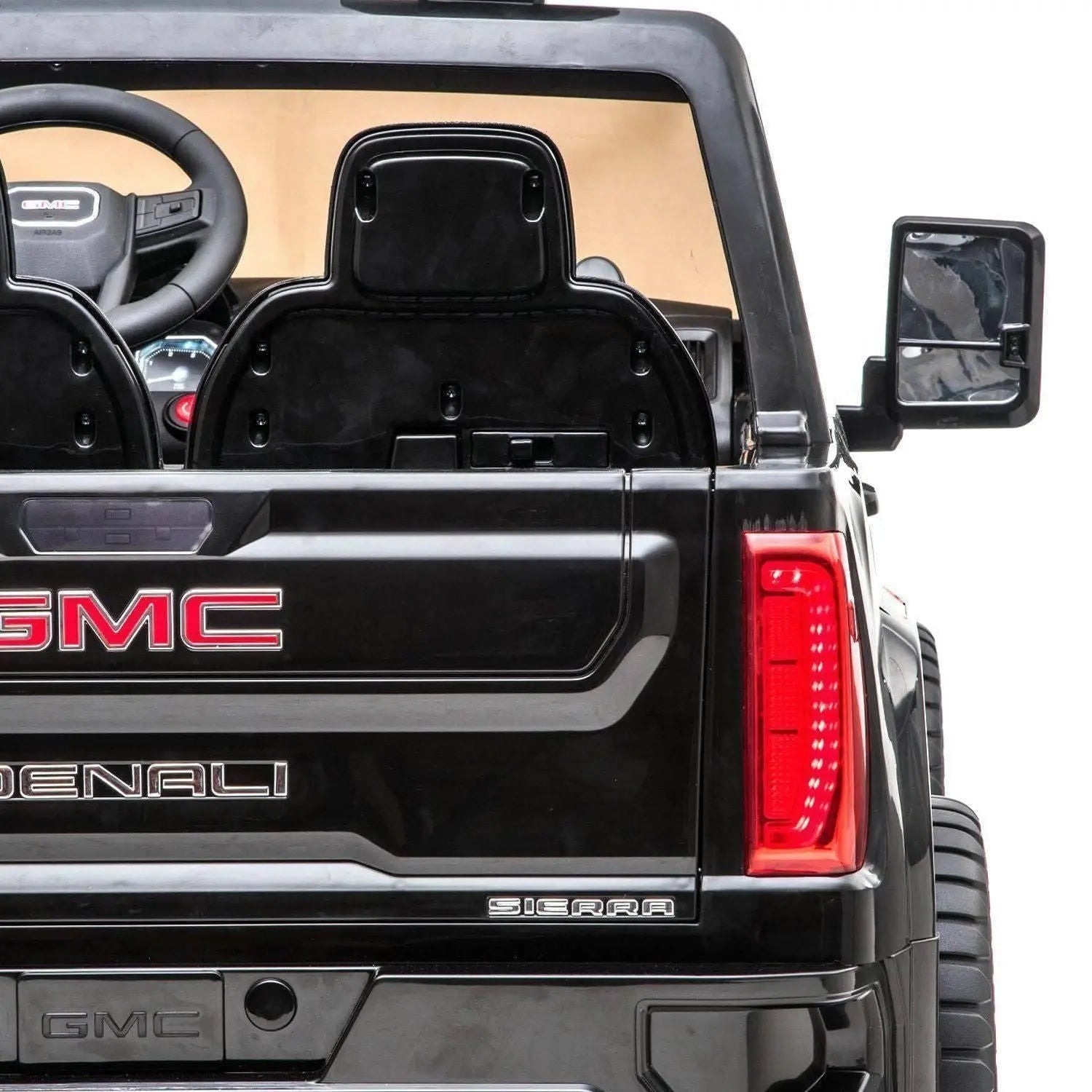 Rear view of black GMC Denali Sierra 2-seater ride-on toy car with steering wheel