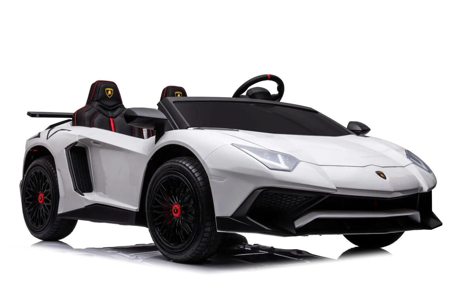White two-seater Lamborghini Aventador kids ride-on car with black wheels and red accents