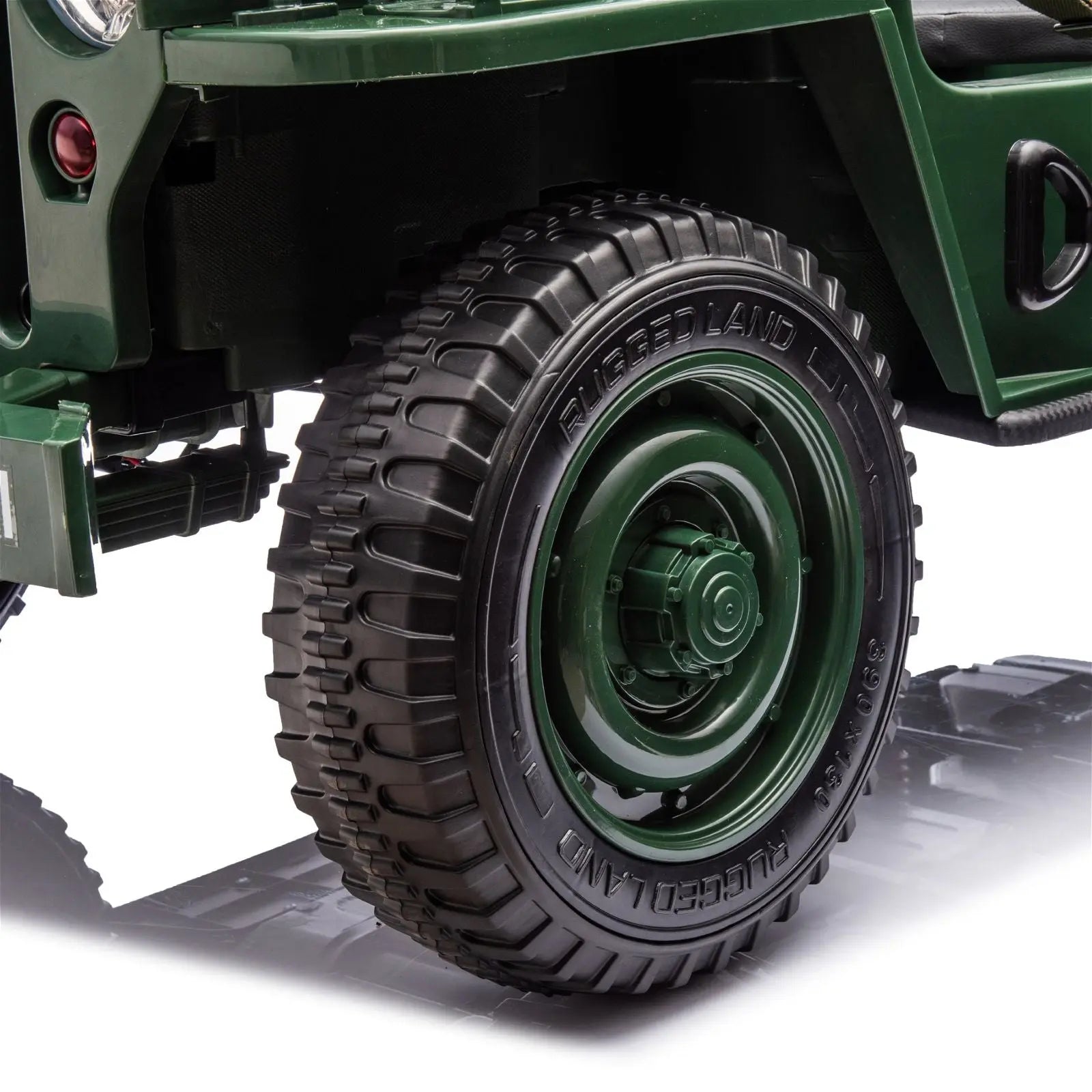 Close-up of rugged black tire on green military-style electric ride-on jeep for kids