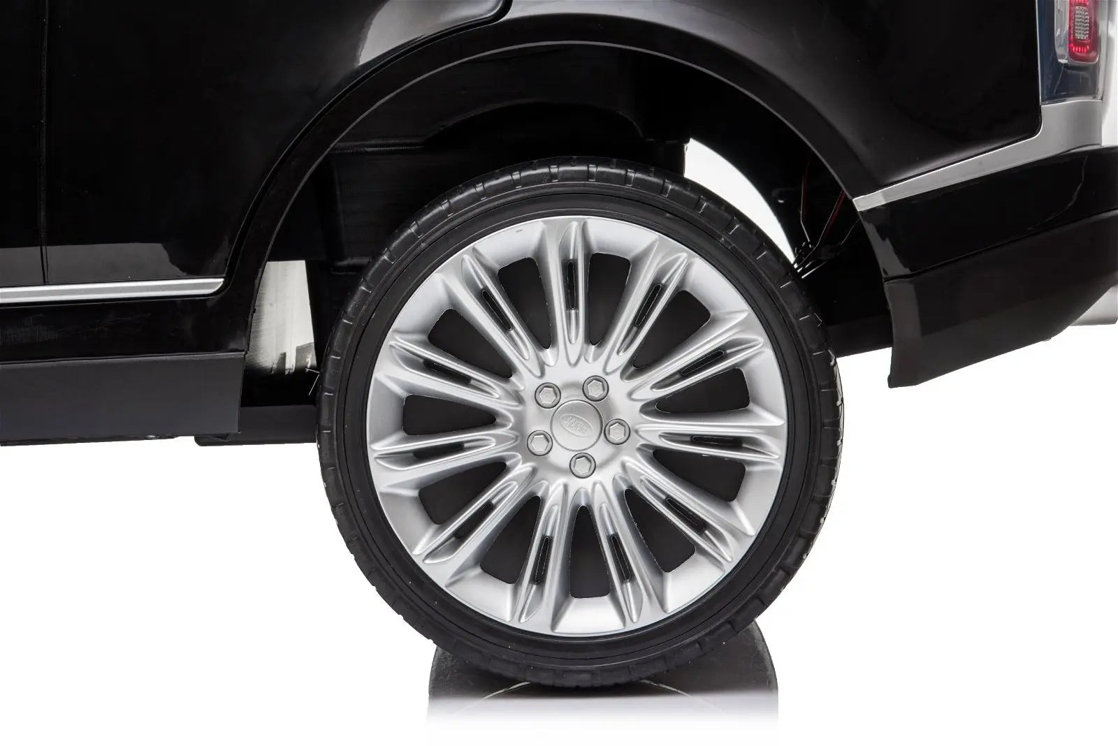 Close-up of black ride-on SUV with detailed silver wheel and tire.