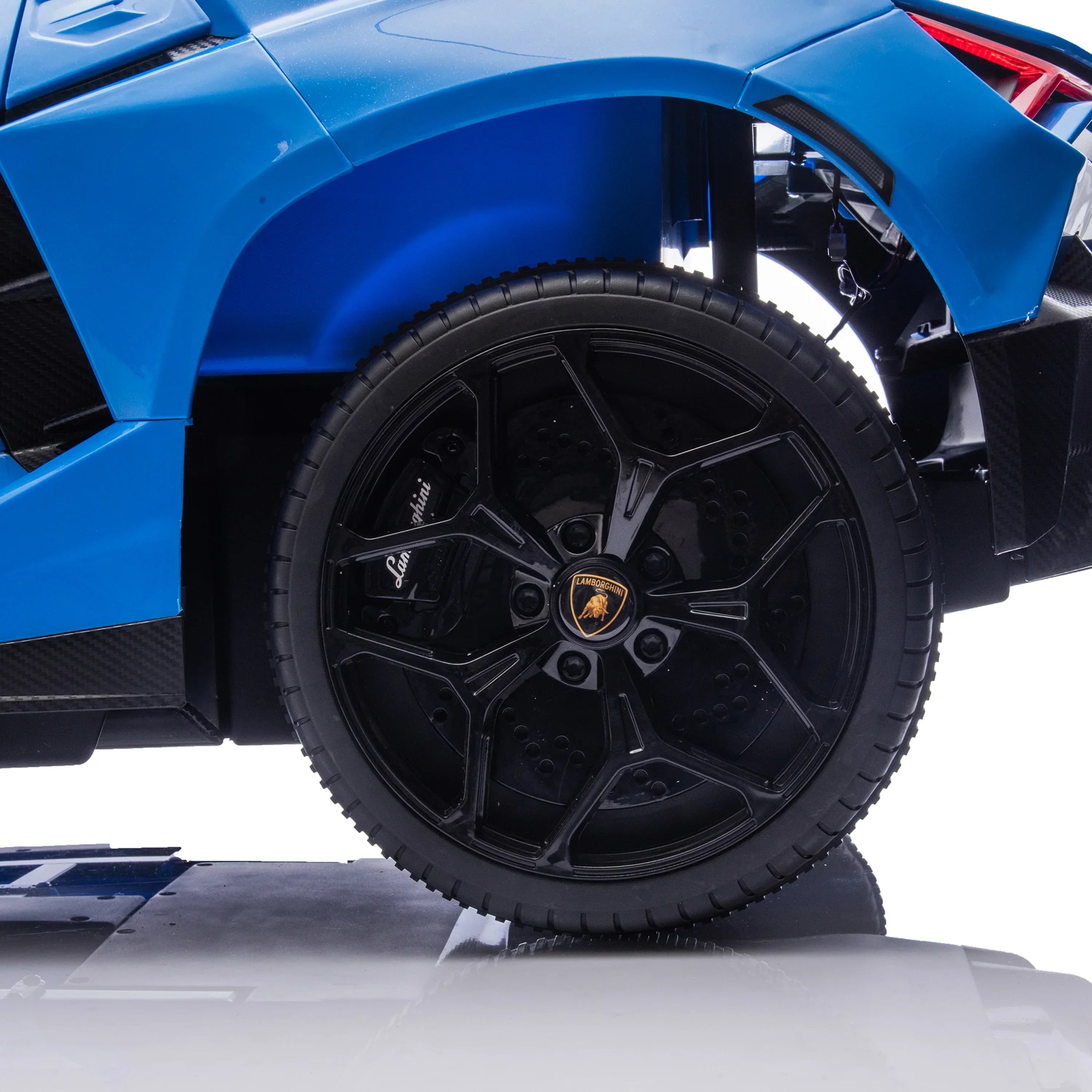 Close-up of black Lamborghini wheel on blue toy sports car
