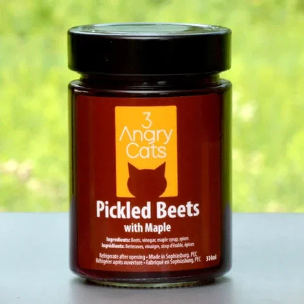 Jar of 3 Angry Cats Pickled Beets with Maple on outdoor table, closeup, label visible
