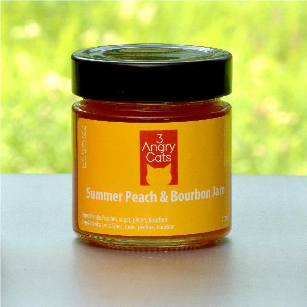 Jar of 3 Angry Cats Summer Peach & Bourbon Jam with black lid on outdoor surface