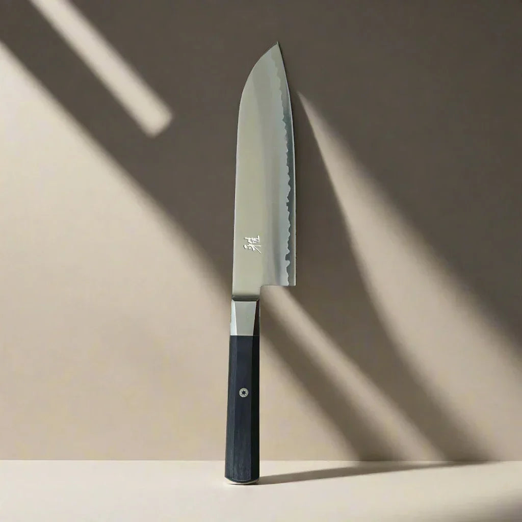 Japanese chef knife with straight blade and dark handle on neutral background, kitchen gear