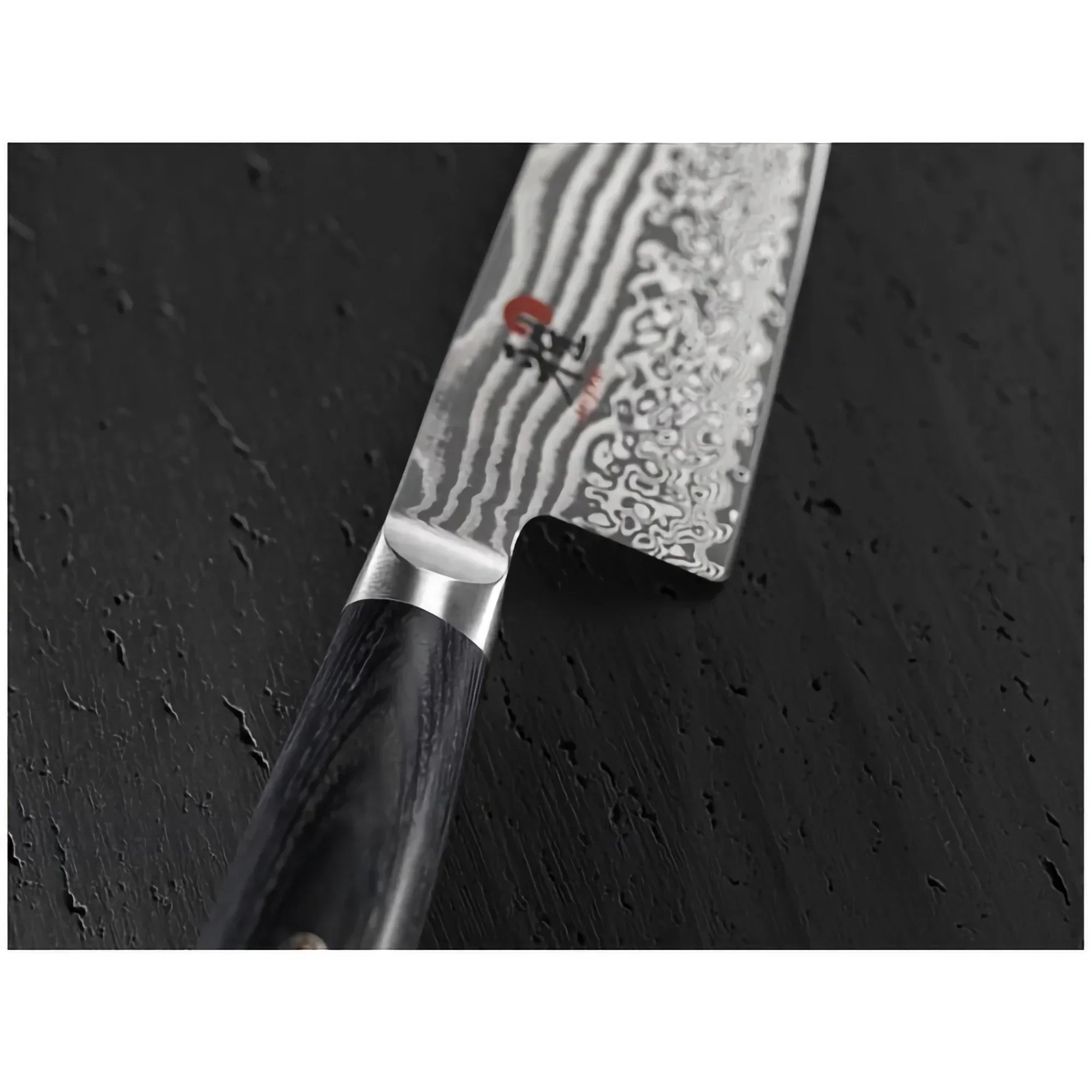 Damascus steel kitchen knife with dark wood handle on black textured surface
