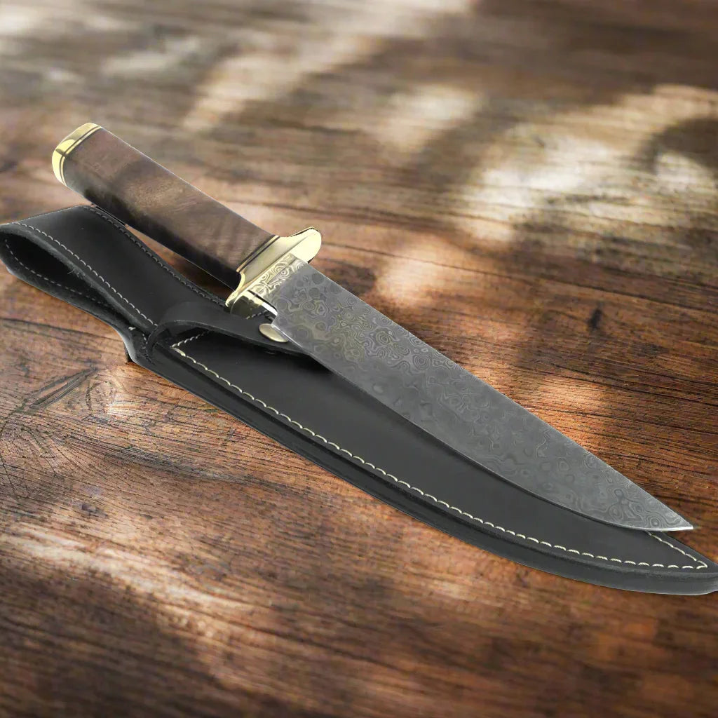 Damascus steel hunting knife with wood handle and leather sheath on rustic wood surface
