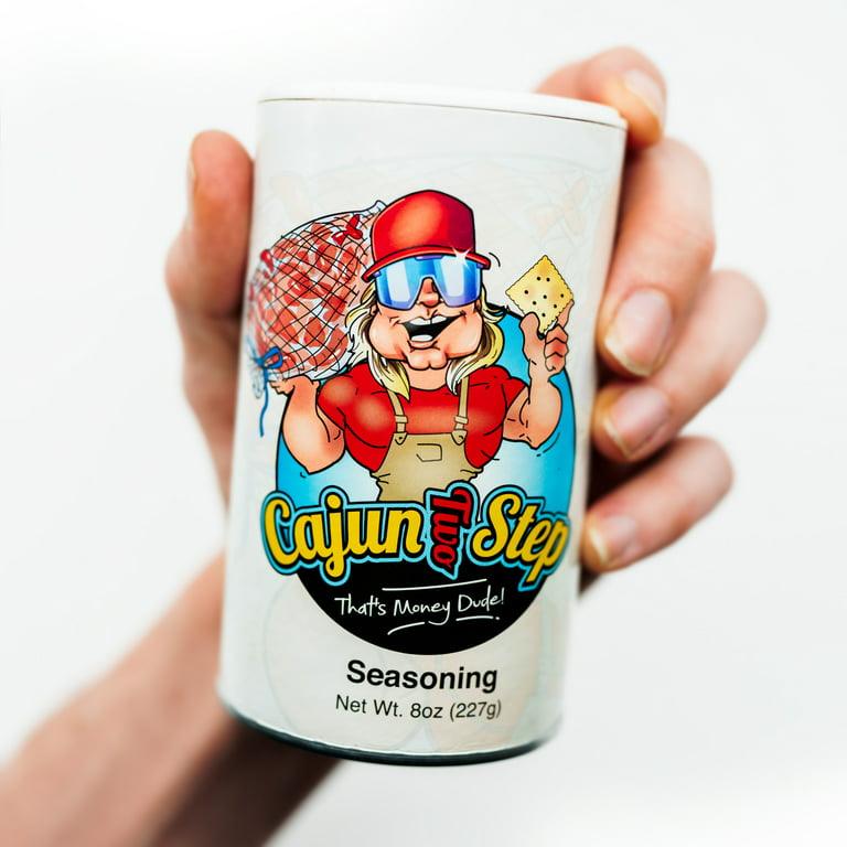 Hand holding Cajun Two Step seasoning container with cartoon chef logo and bold label