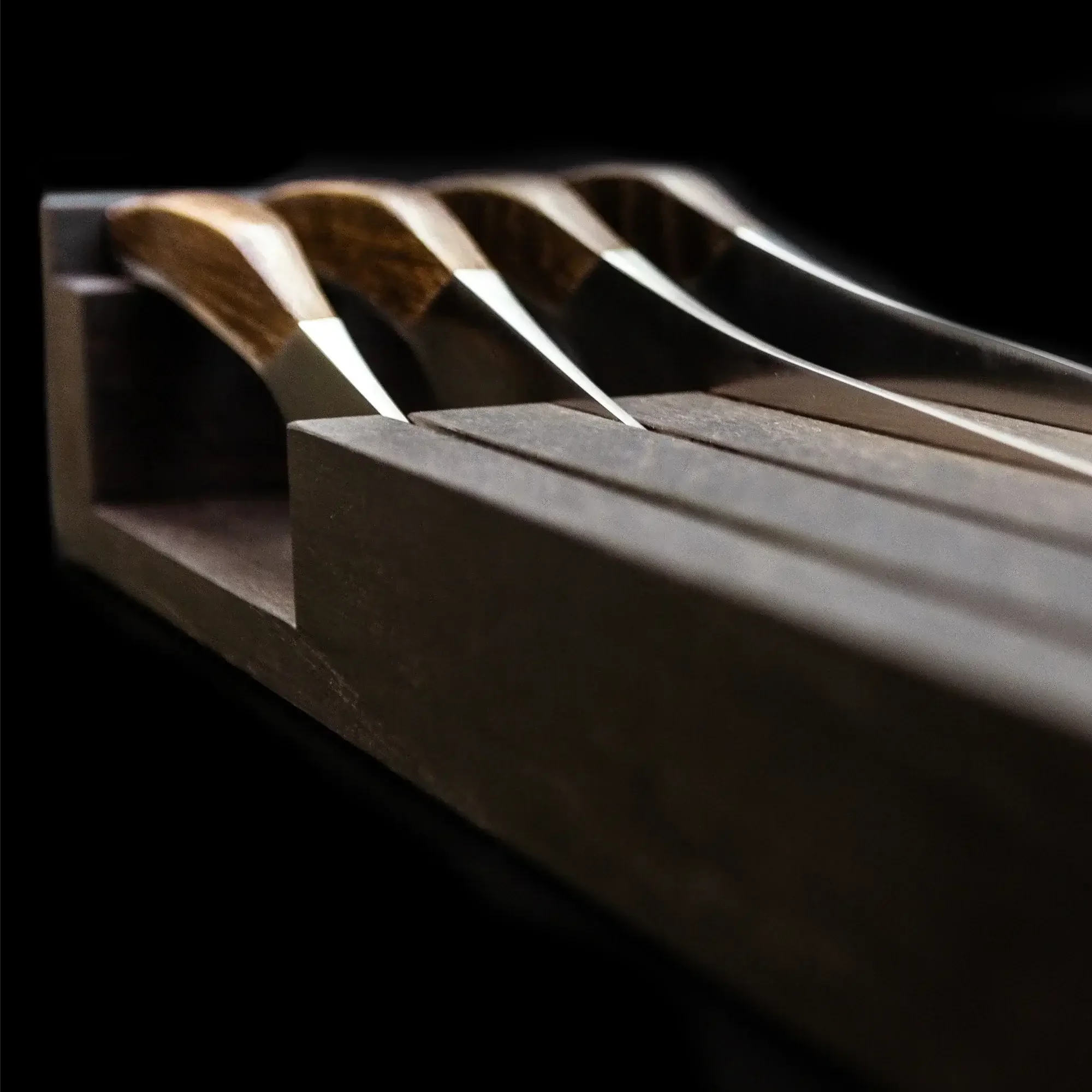 Close-up of hunting knives with wooden handles in a dark wood block, outdoor gear