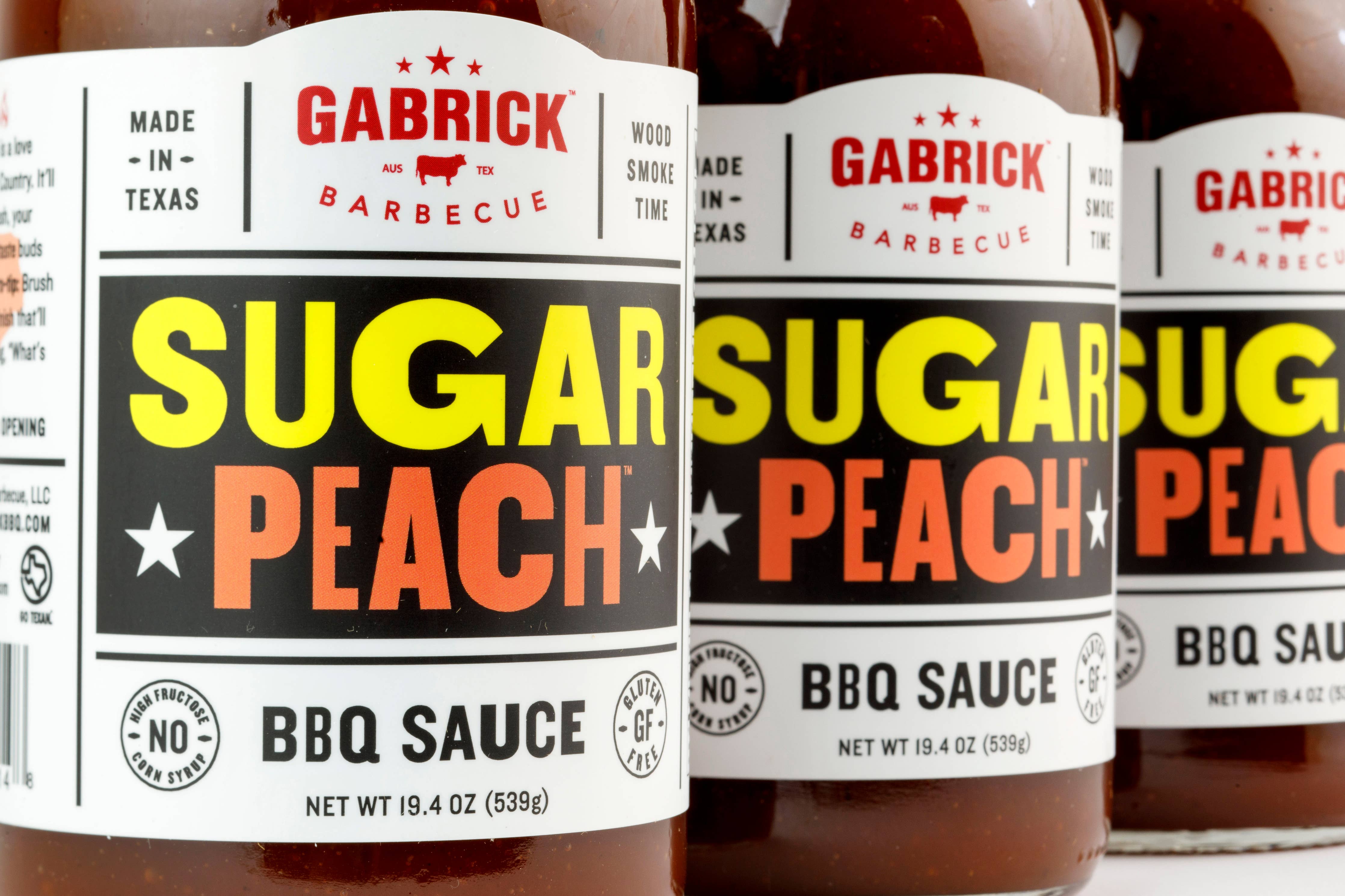 Gabrick Sugar Peach BBQ sauce bottles, gluten-free Texas barbecue condiment.