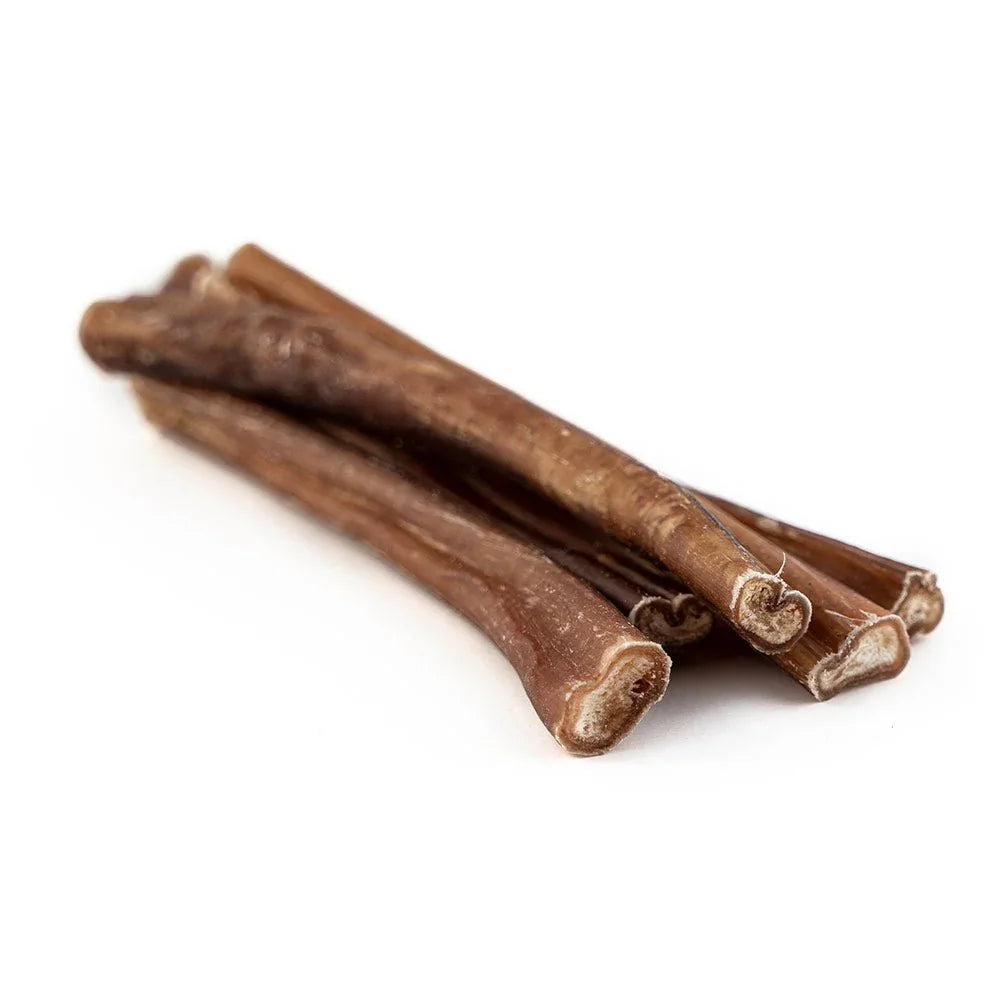 Pile of thin bully sticks dog chews on white background