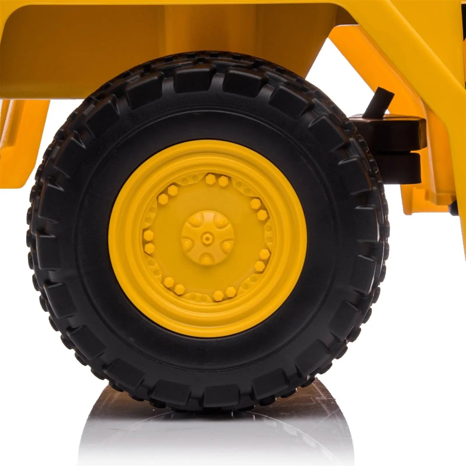 Close-up of a yellow and black toy dump truck wheel with rugged tread