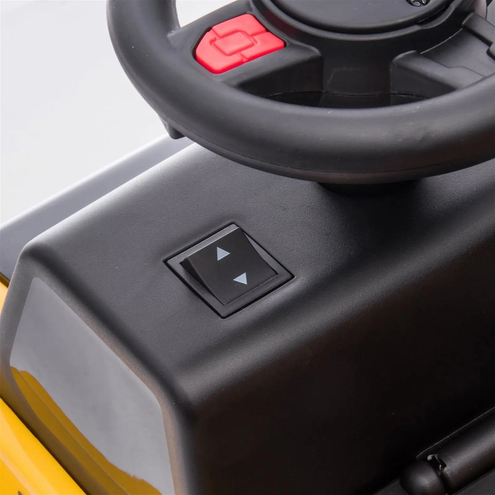 Close-up of a toy dump truck ride-on steering wheel and control buttons