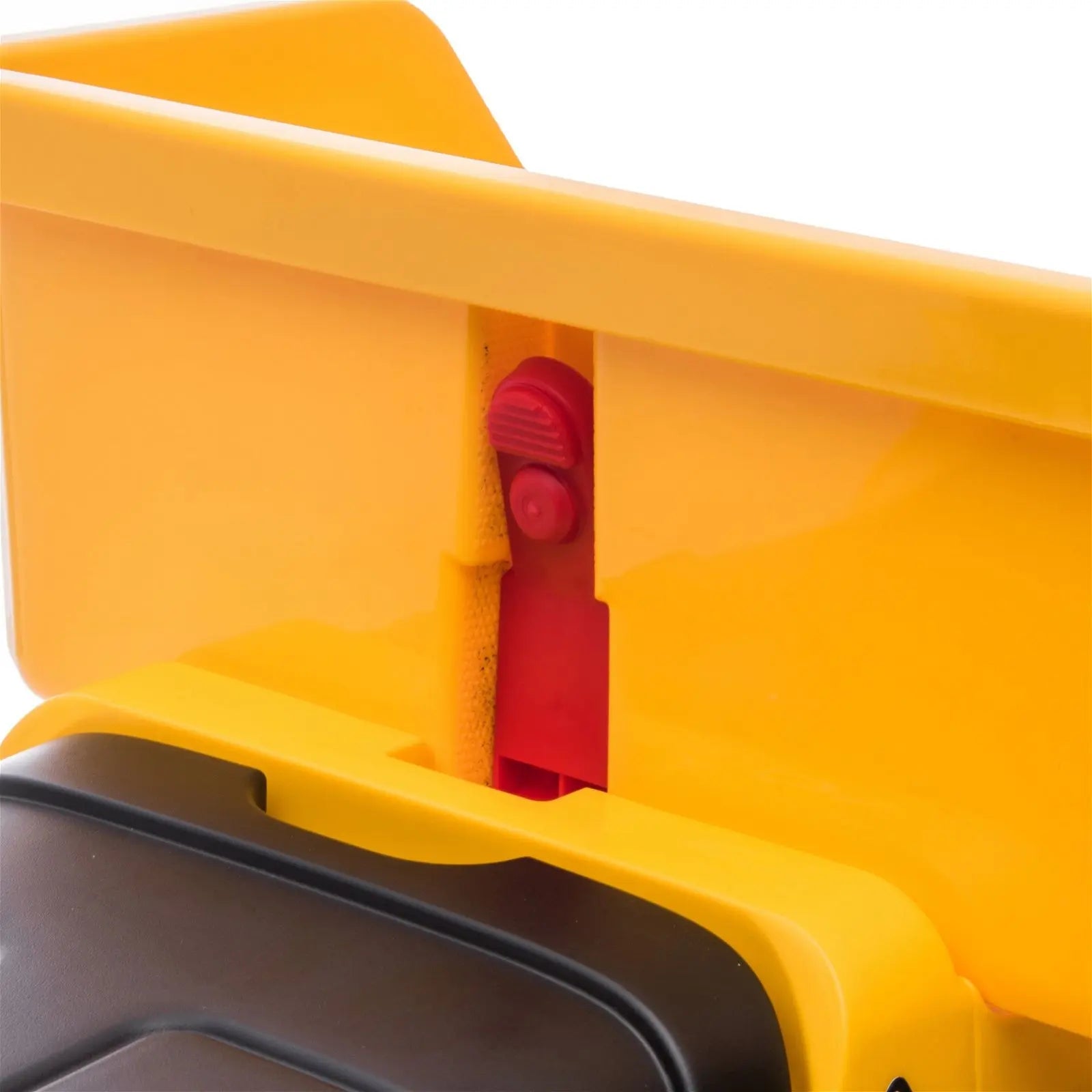 Close-up of yellow plastic dump truck ride-on toy bed and red hinge detail