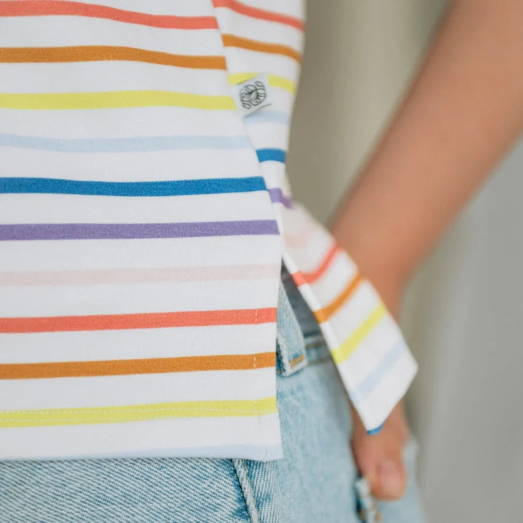 Rainbow striped t-shirt with side tag, paired with light blue denim jeans