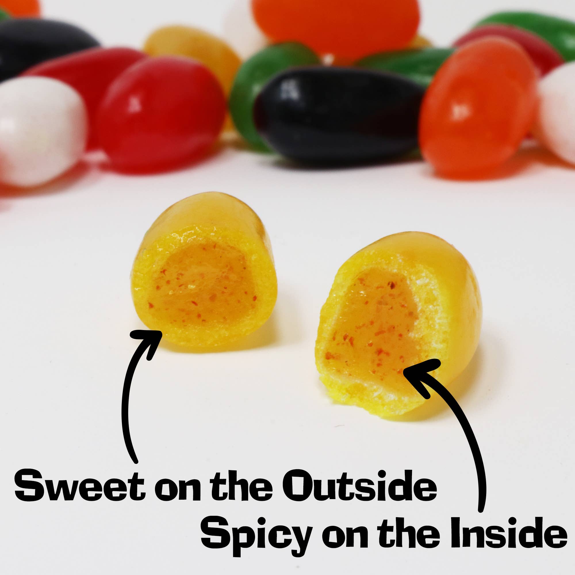 Assorted jelly beans with one yellow jelly bean cut in half showing spicy center, sweet candy