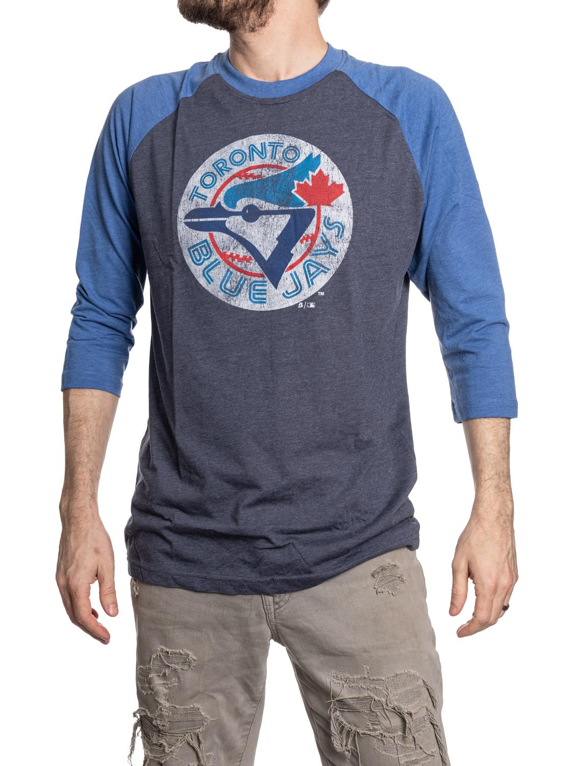 Man wearing blue Toronto Blue Jays raglan shirt and ripped khaki pants