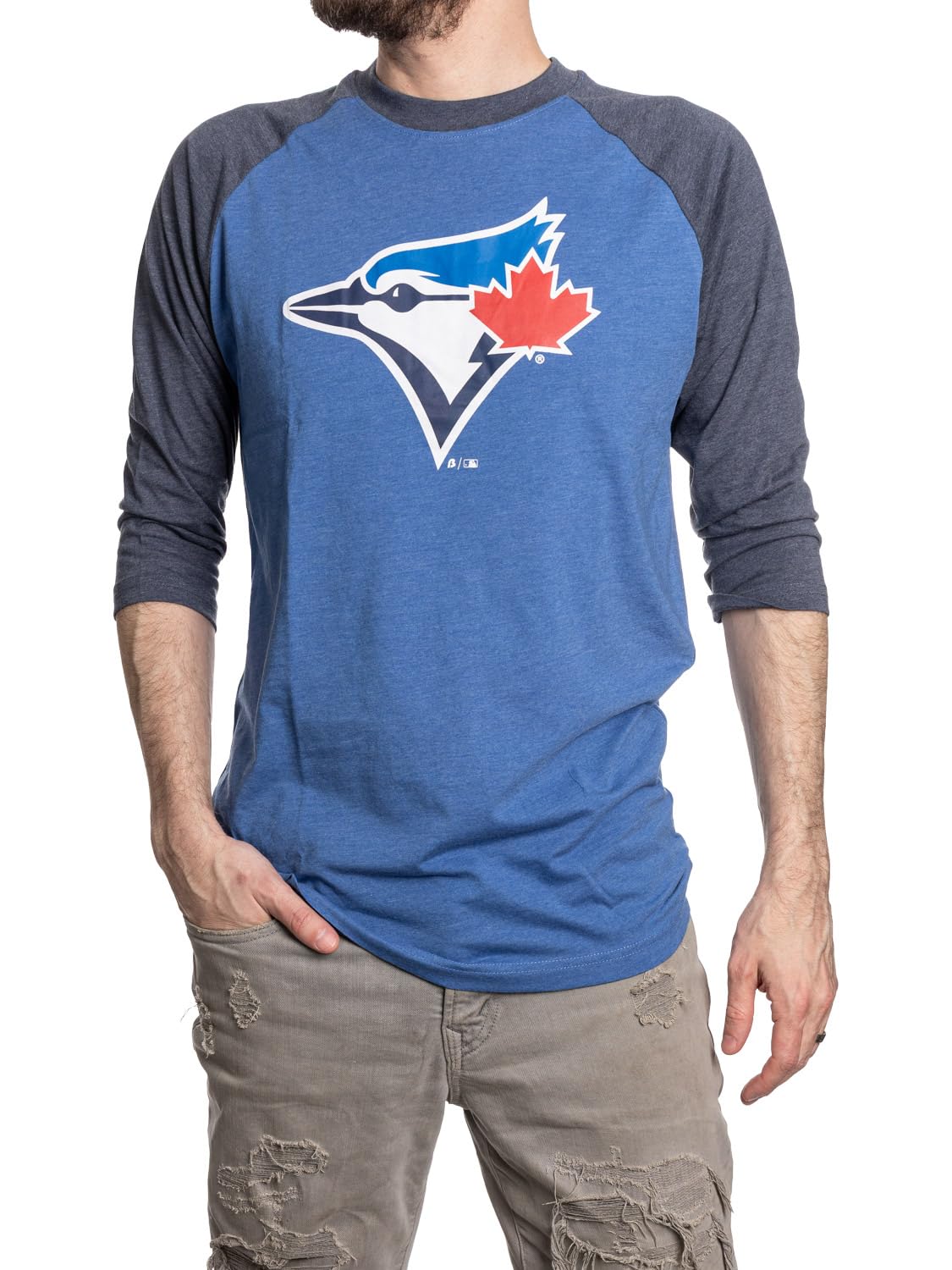 Man wearing blue raglan t-shirt with large bird logo and distressed khaki jeans