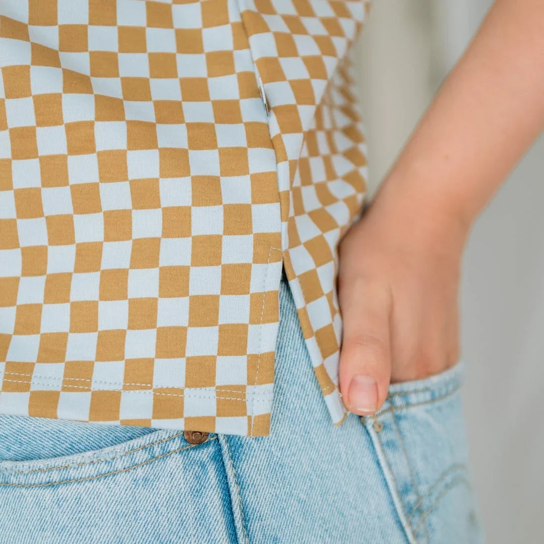 Close-up of yellow checkered shirt with hand in light blue denim jeans pocket