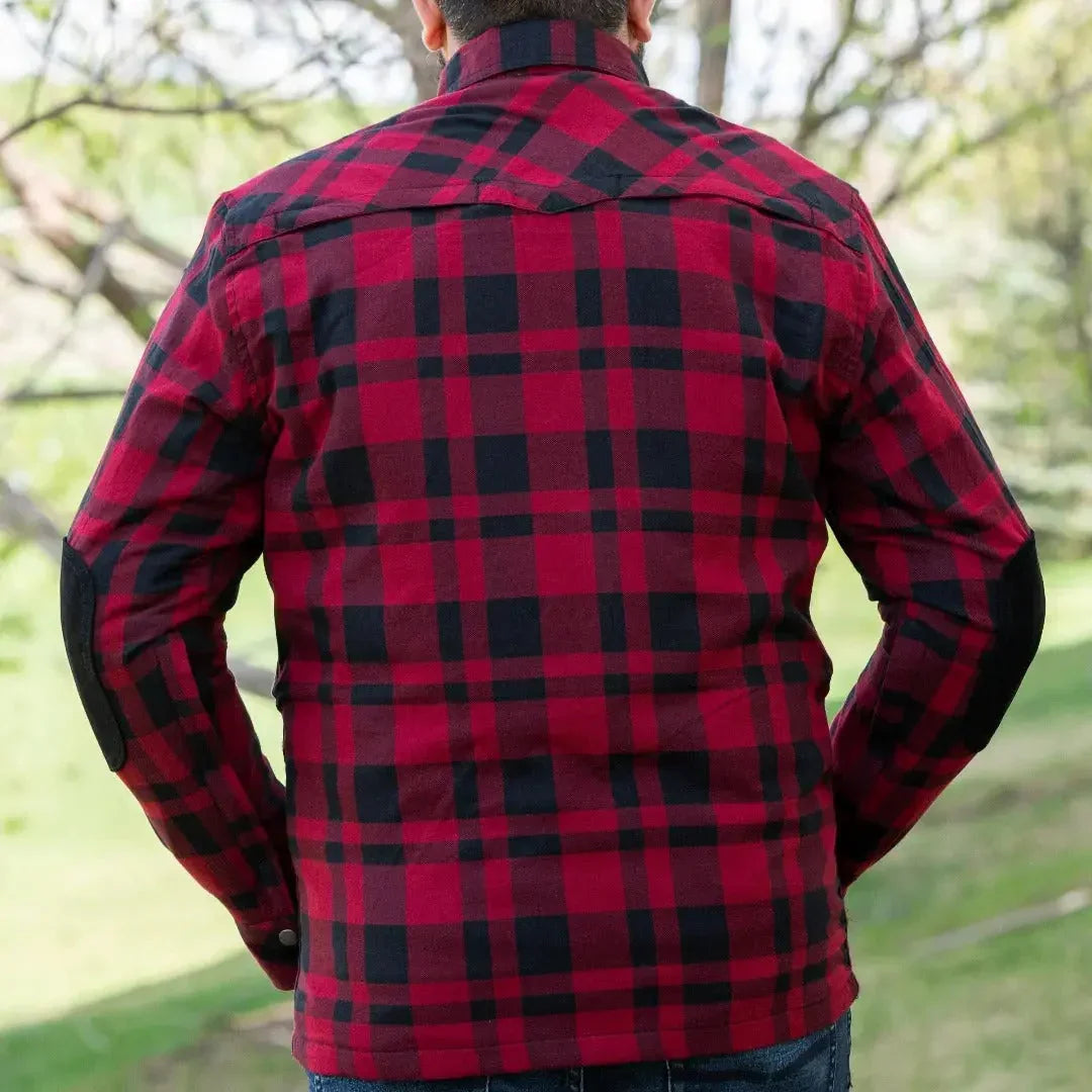 Back view of man wearing red and black plaid armored flannel biker shirt outdoors