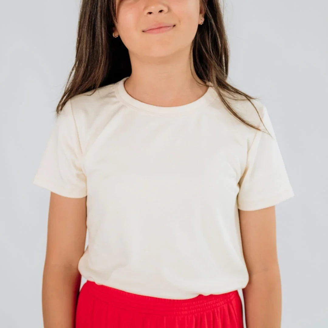 Youth wearing a plain white bamboo T-shirt and red shorts against a light background