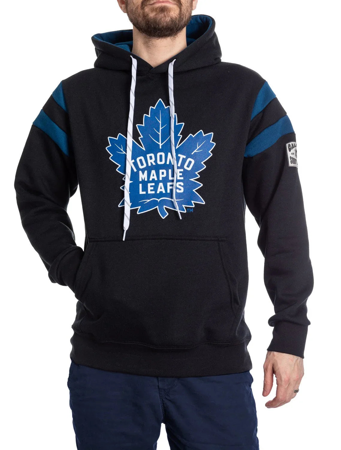 Man wearing black Toronto Maple Leafs varsity hoodie with blue stripes and team logo.