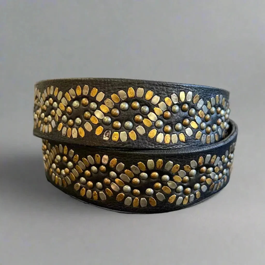 Women's full grain black leather belt with gold-tone studs in wave pattern on gray background