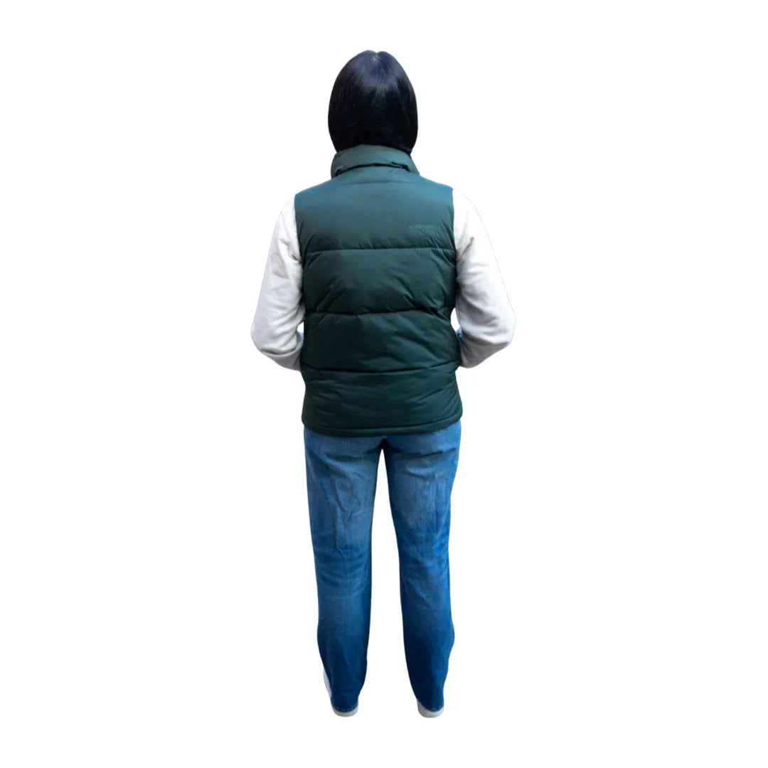 Back view of woman wearing green puffer vest, white sleeves, and blue jeans