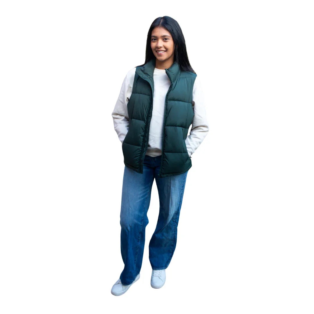 Woman wearing a green puffer vest, casual jeans, and a white top, front view