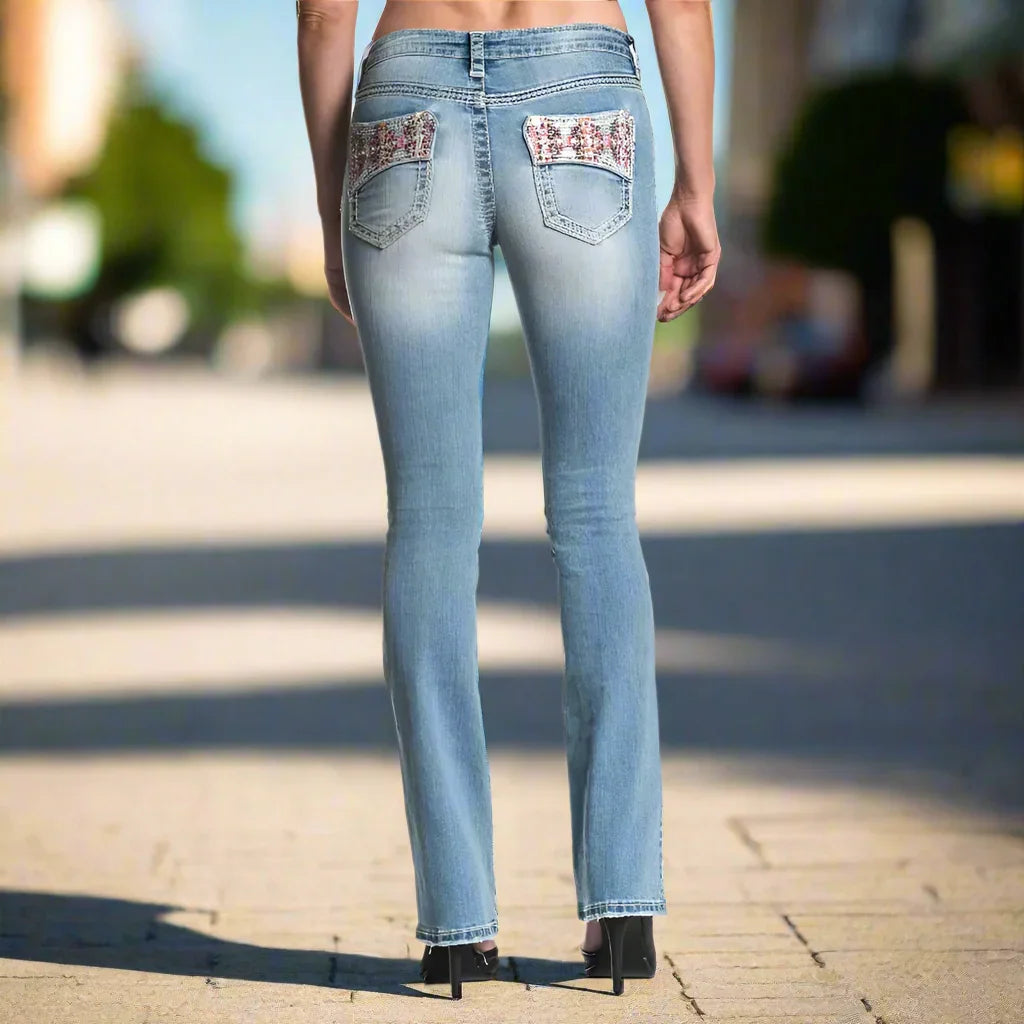 Woman wearing light wash Affliction Jade Aries Ember jeans with embellished back pockets outdoors