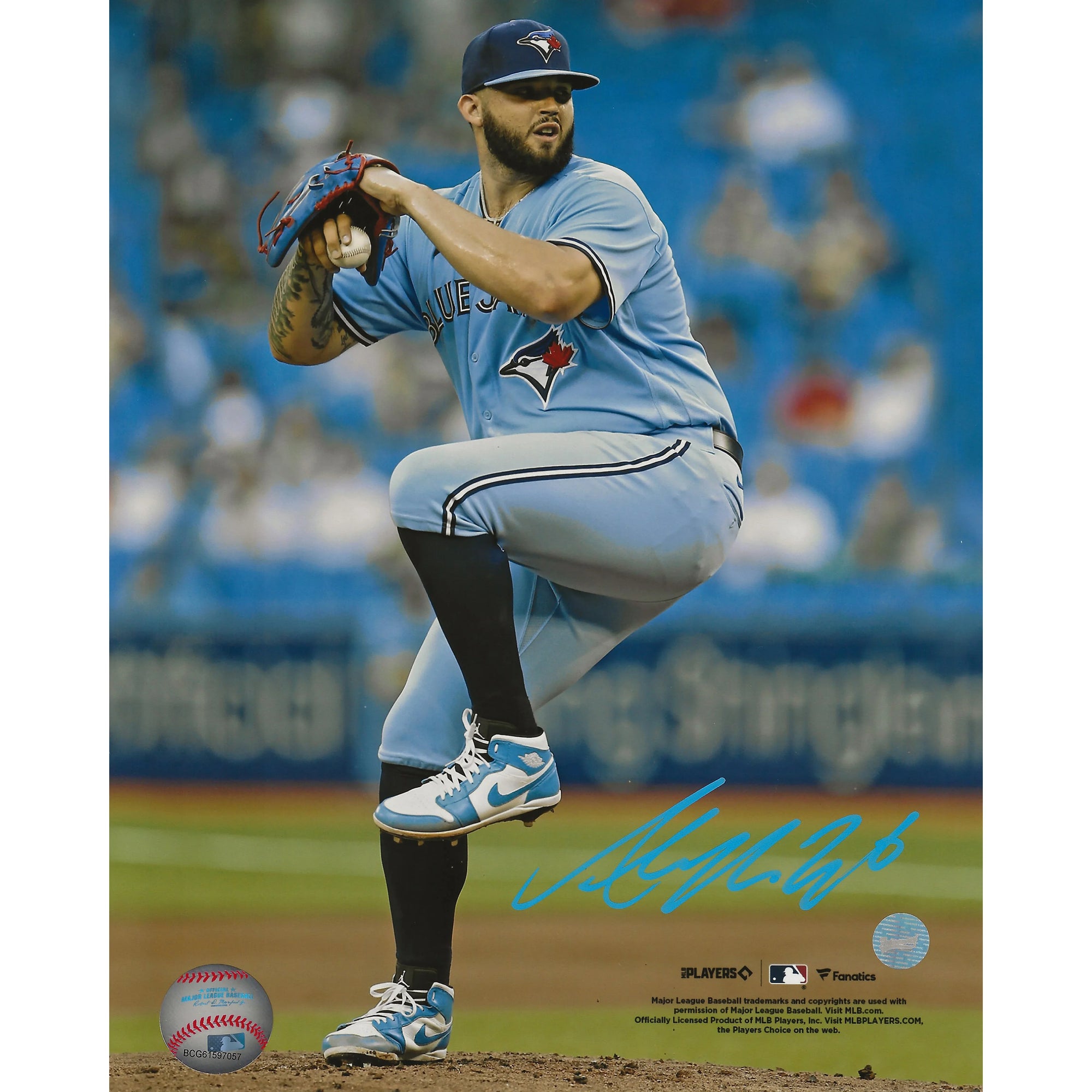 Toronto Blue Jays pitcher in blue uniform mid-pitch on baseball field, autograph visible