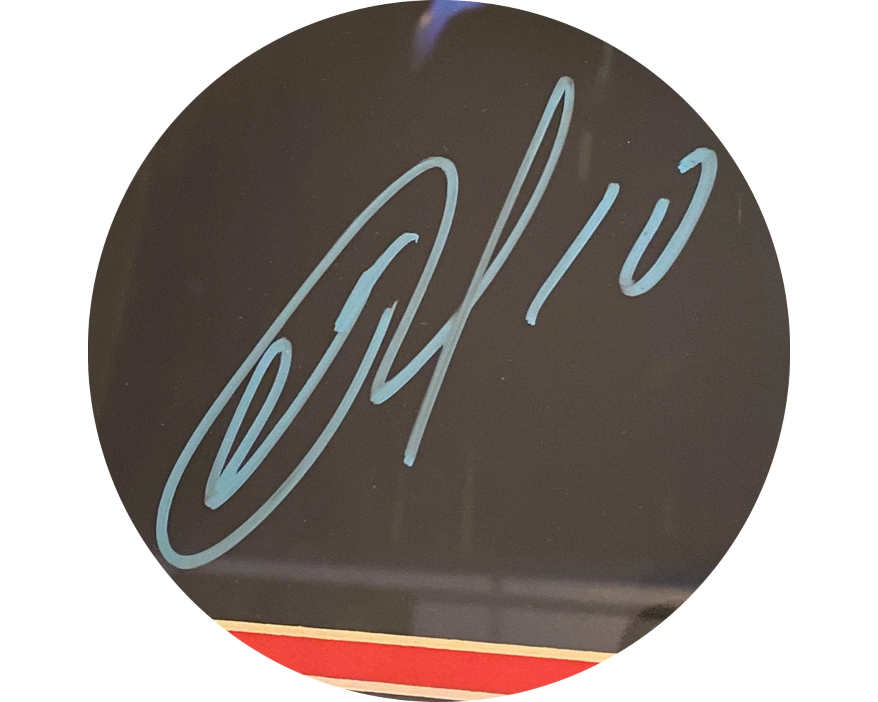 Close-up of blue sports autograph on black background with red and gold border
