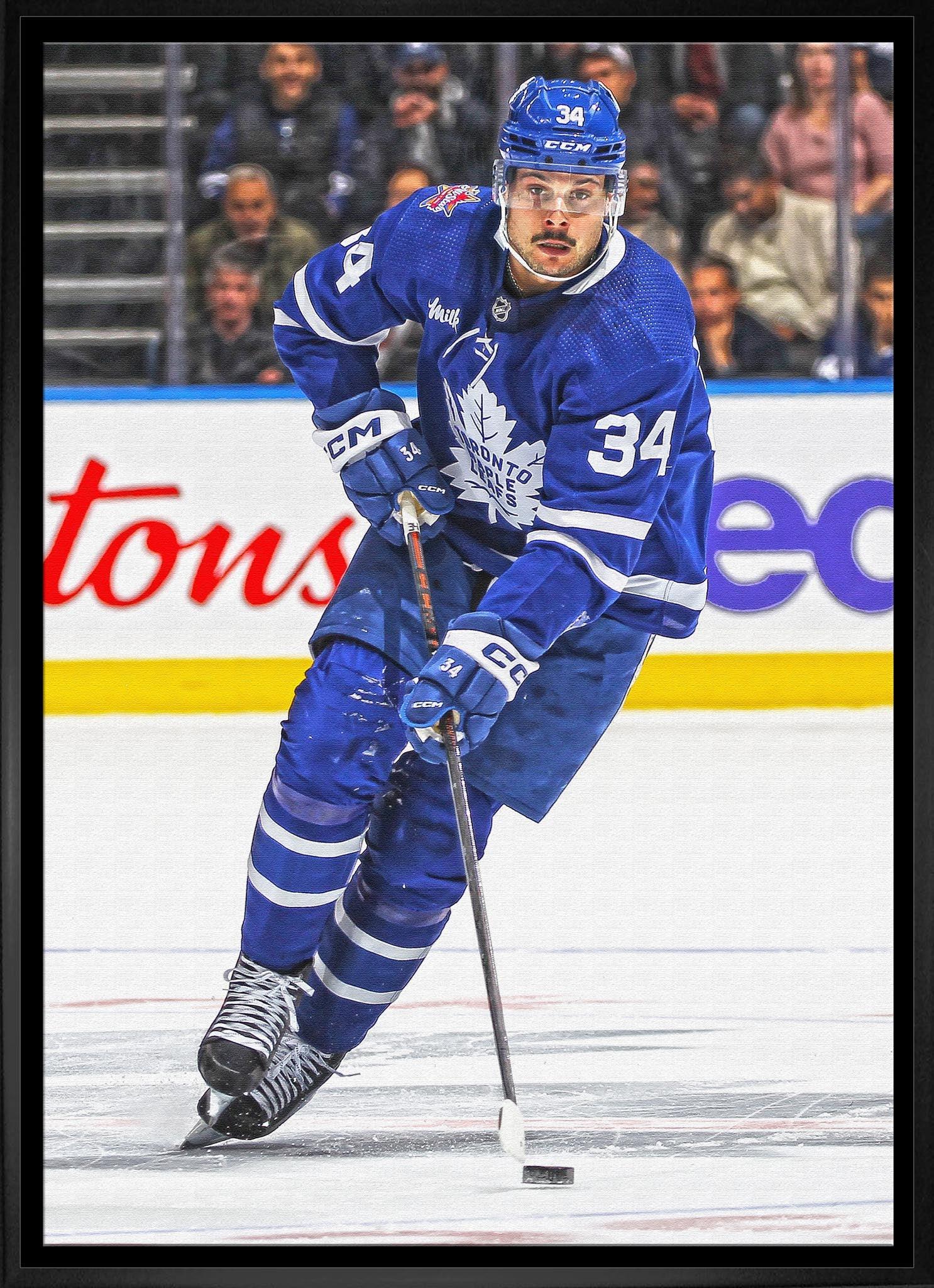 Toronto Maple Leafs hockey player in blue jersey skating on ice during game action
