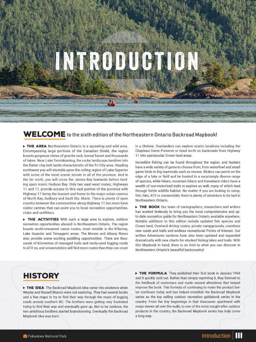 Two people canoeing on a lake with forested hills in Northeastern Ontario, mapbook introduction page.