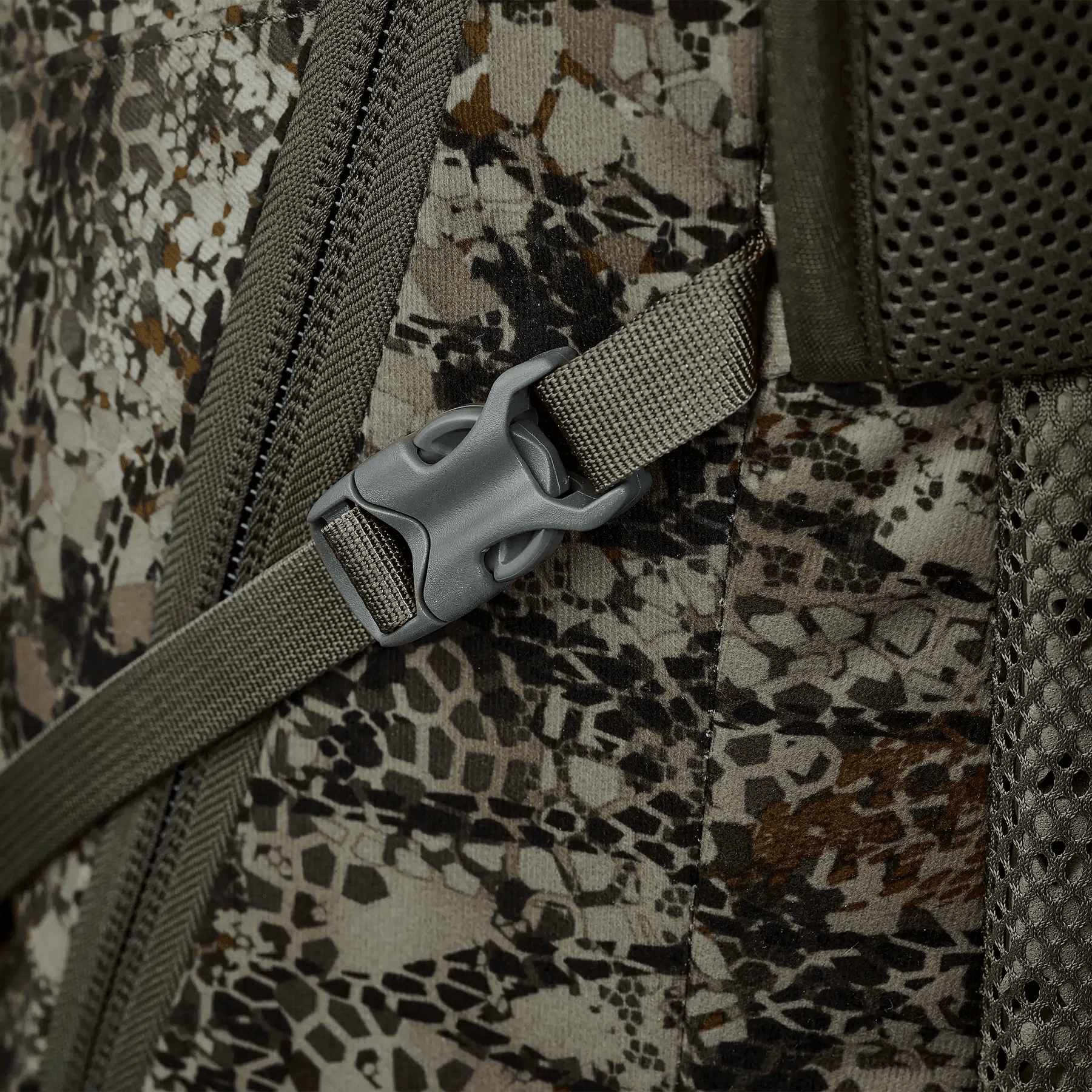 Close-up of camo backpack strap and buckle on tactical outdoor hunting pack