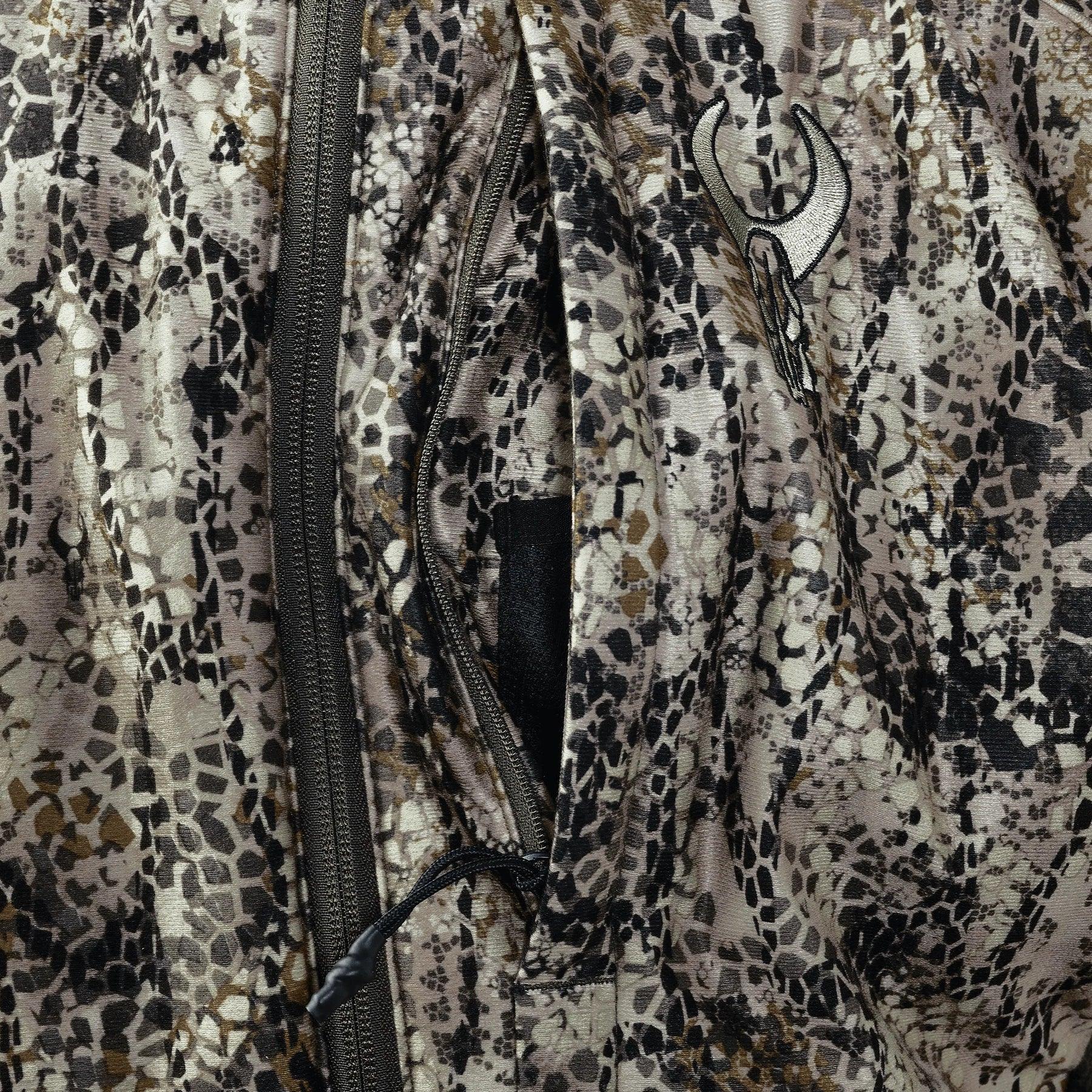 Close-up of camouflage hunting jacket with zipper pocket and embroidered skull logo