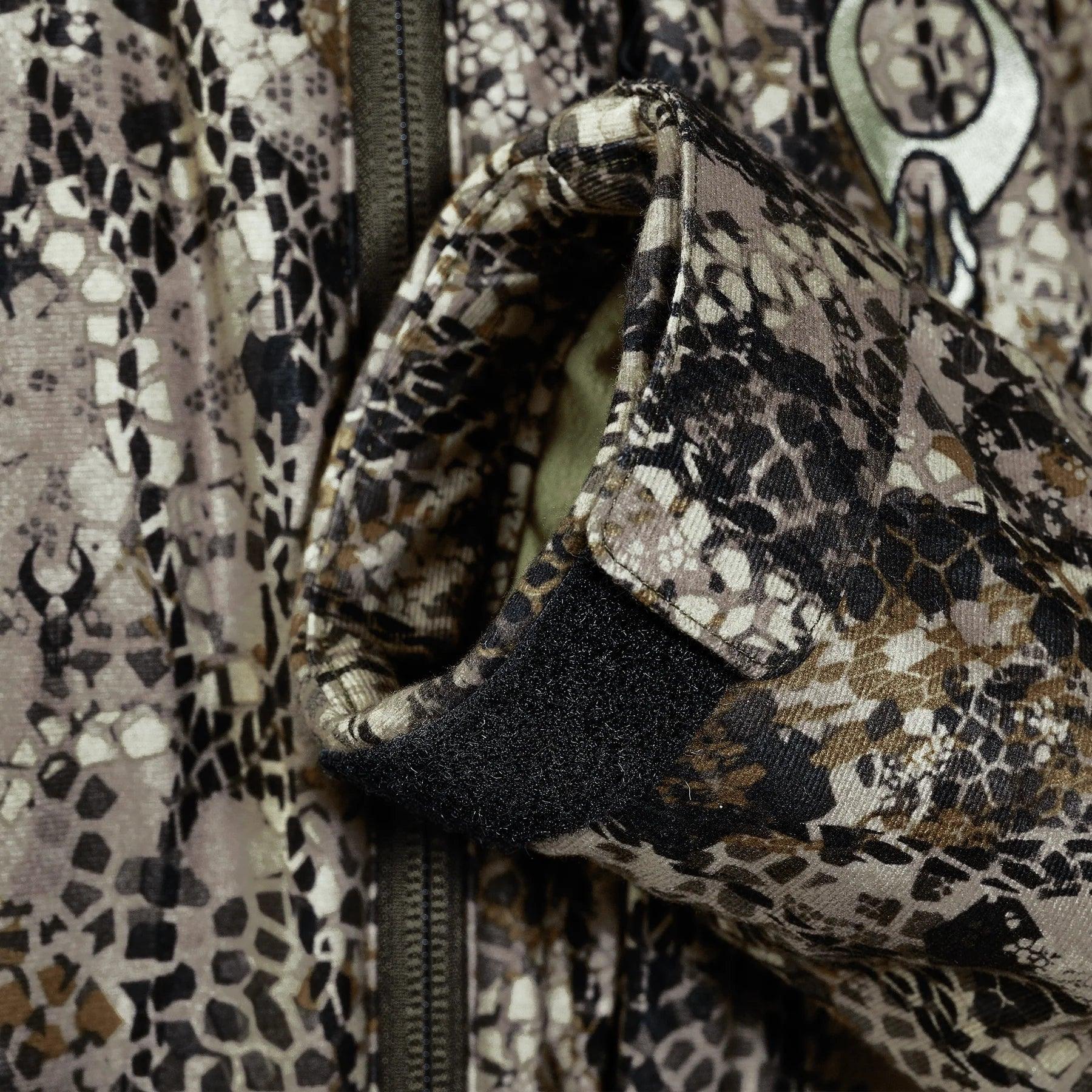 Close-up of a camouflage jacket sleeve with velcro cuff and zipper detail