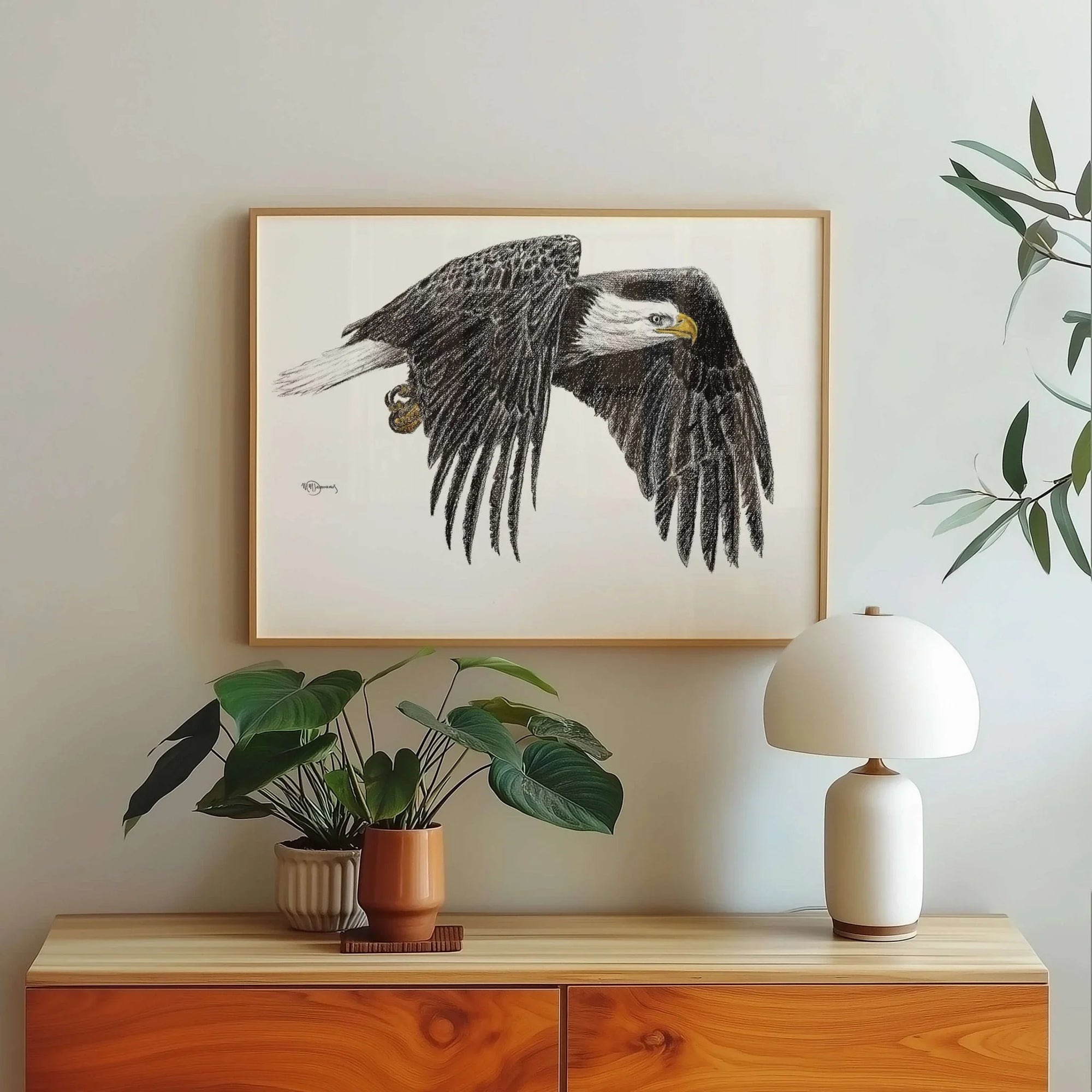 bald eagle illustration wall art above modern sideboard with plants and white lamp