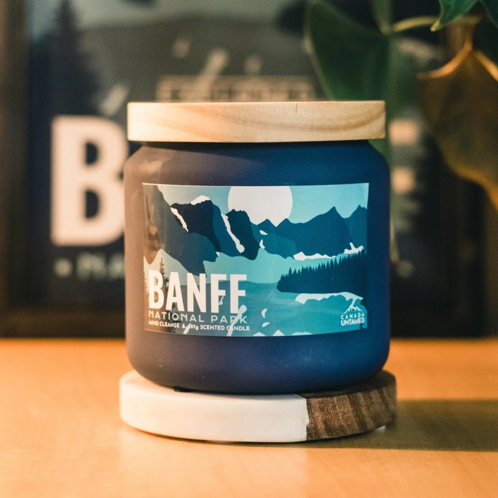 Banff National Park scented candle with mountain design on wooden table