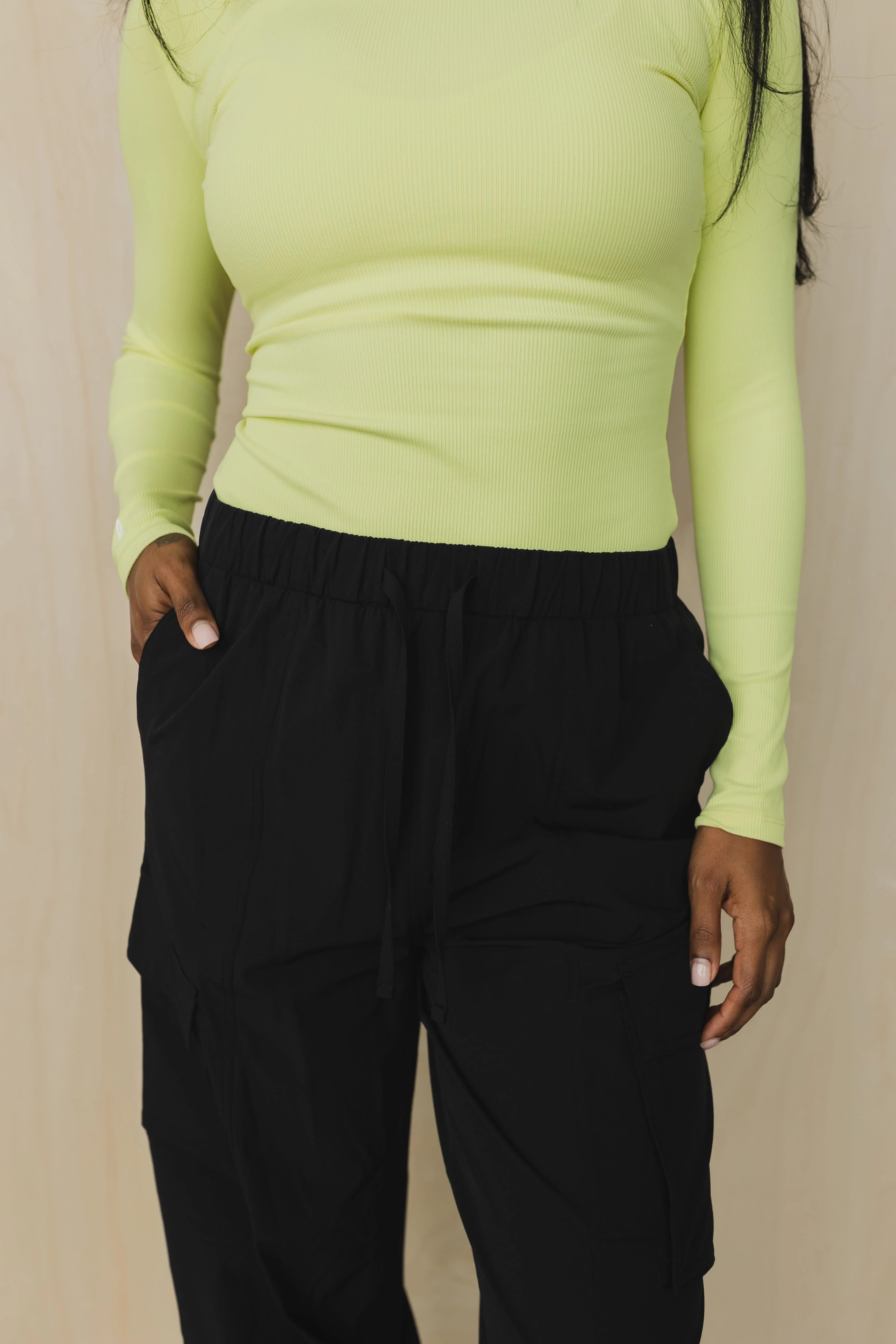 Woman in yellow ribbed long sleeve top and black cargo jogger pants