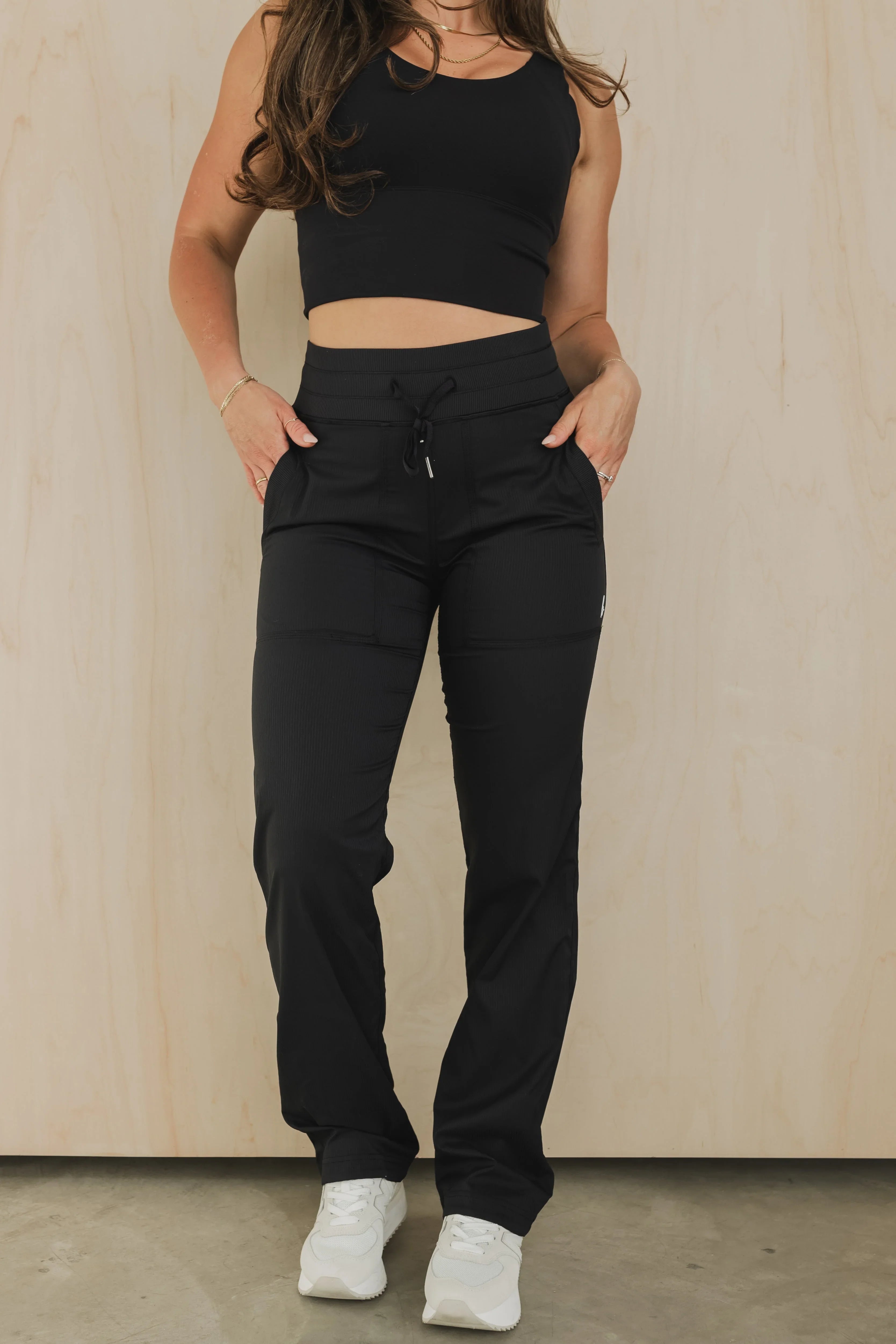 Woman wearing black drawstring jogger pants and crop top, casual activewear style