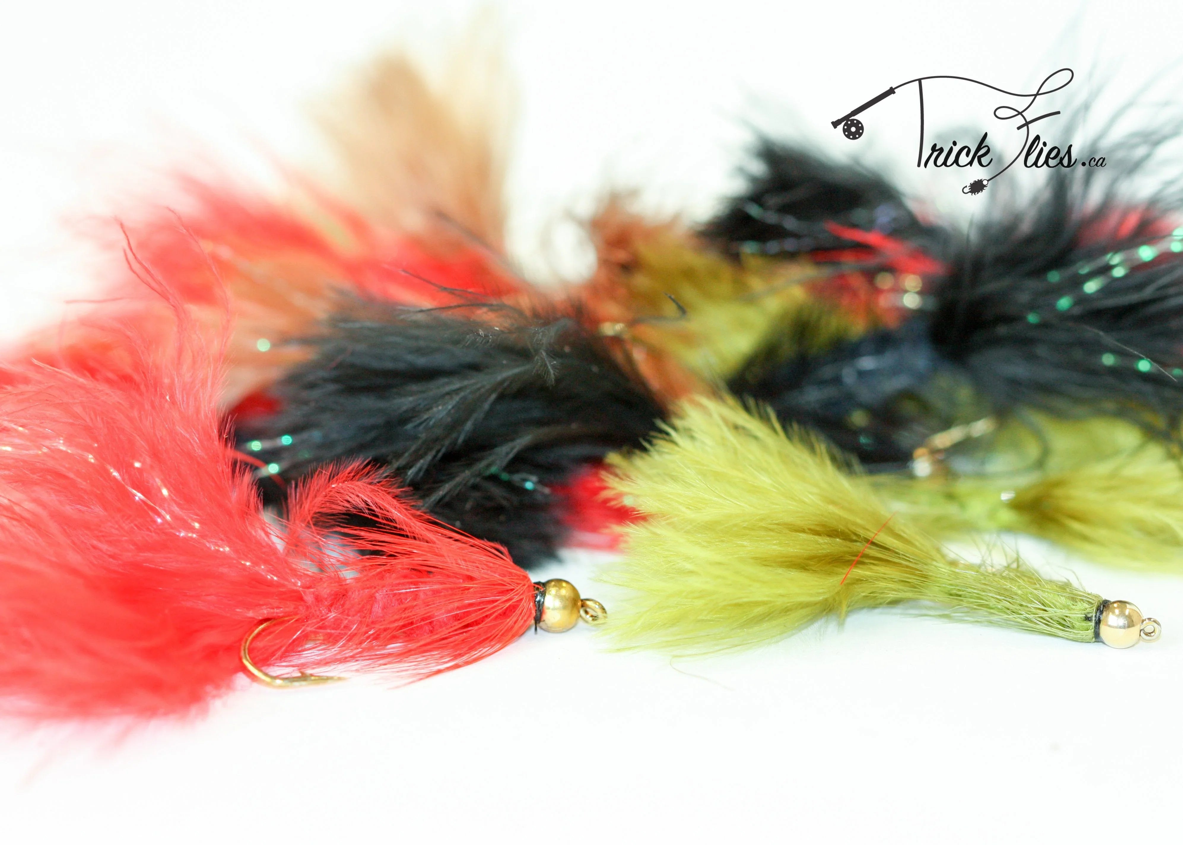 Colorful feathered woolly bugger fishing flies on white background with Trick Flies logo