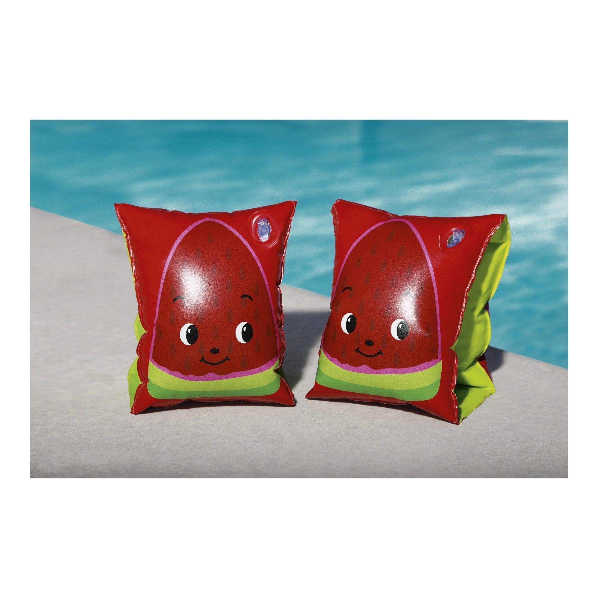 Watermelon-themed kids swim arm floaties with cartoon faces by a pool