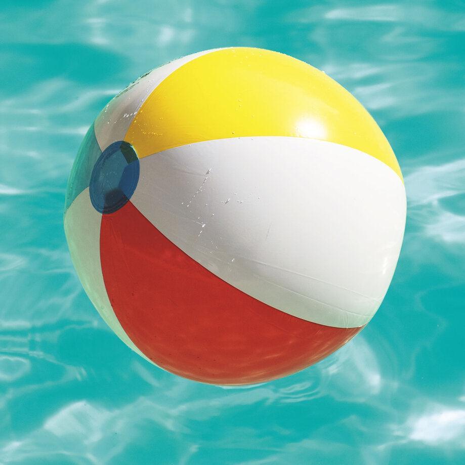 Colorful beach ball floating in a swimming pool with clear blue water