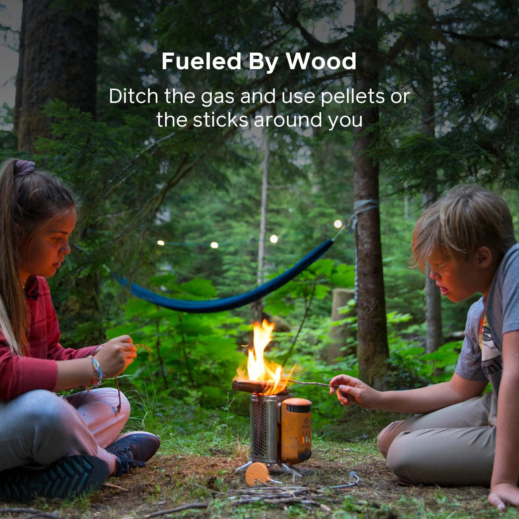 Kids using BioLite CampStove 2 for outdoor cooking in a forest camp setting with hammock