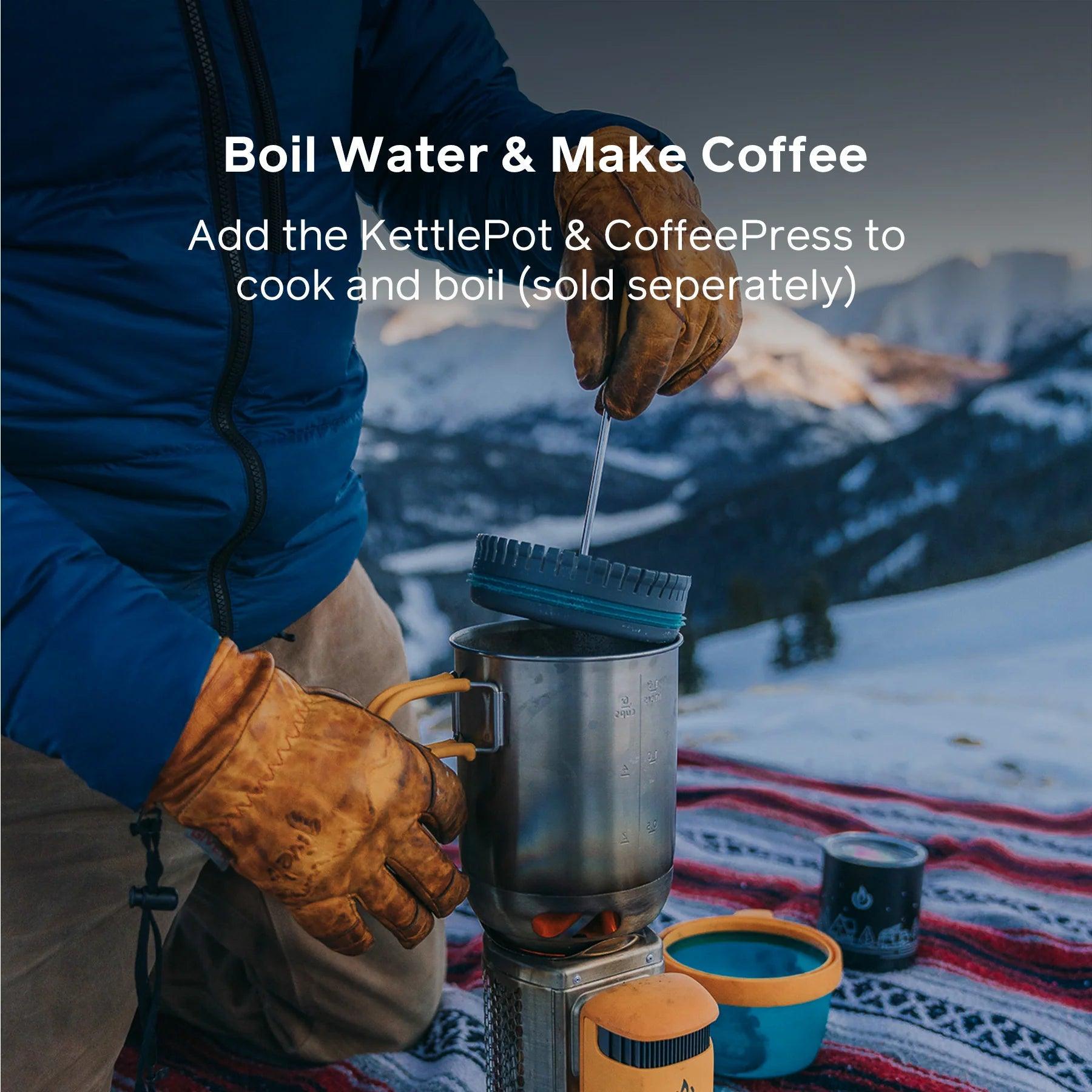 Person using BioLite CampStove 2 with KettlePot and CoffeePress outdoors in snowy mountains