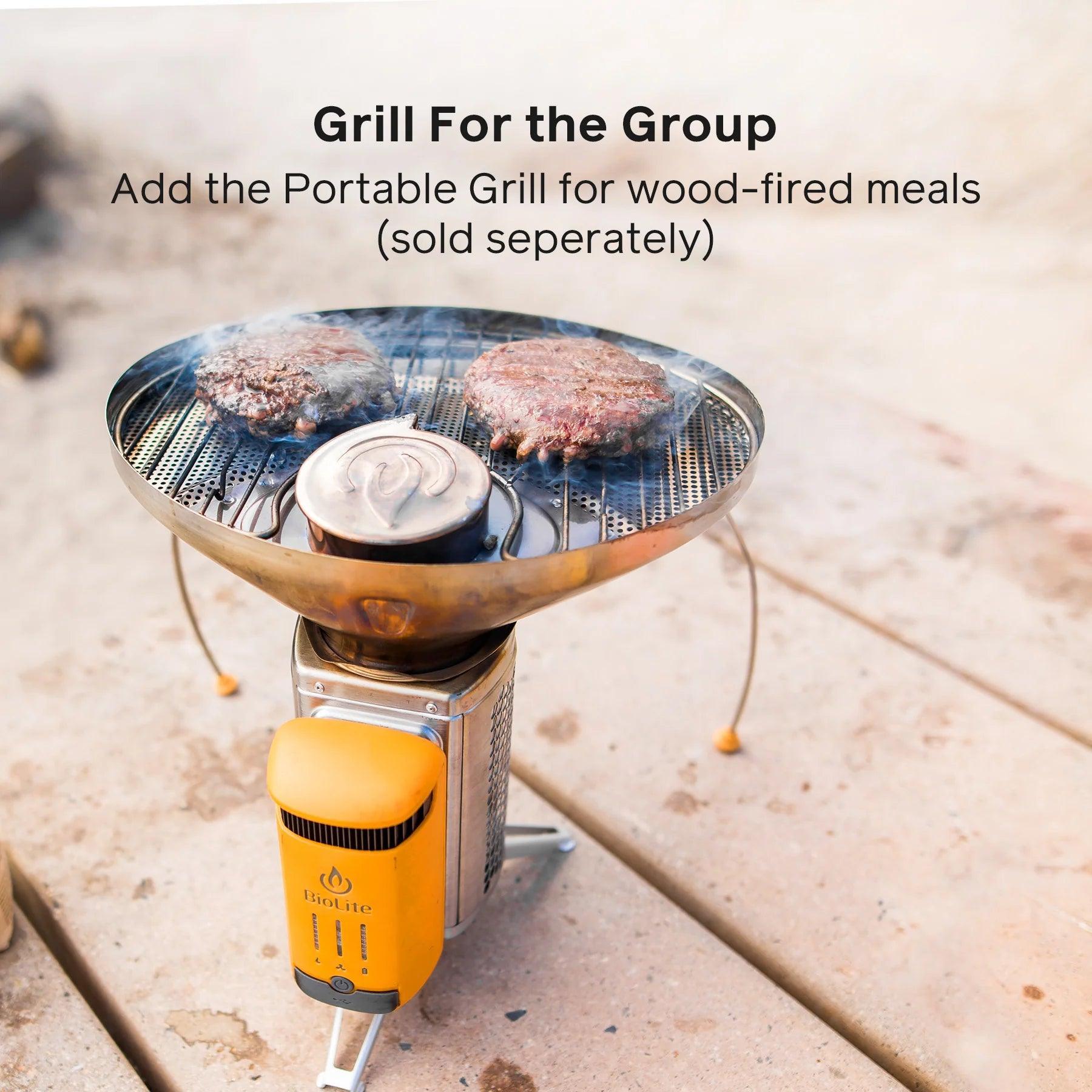 BioLite CampStove 2 portable grill cooking burgers outdoors on a wooden surface