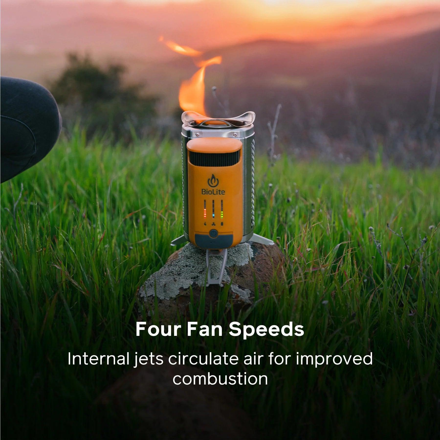 BioLite CampStove 2 on grass with flame, outdoor camping at sunset